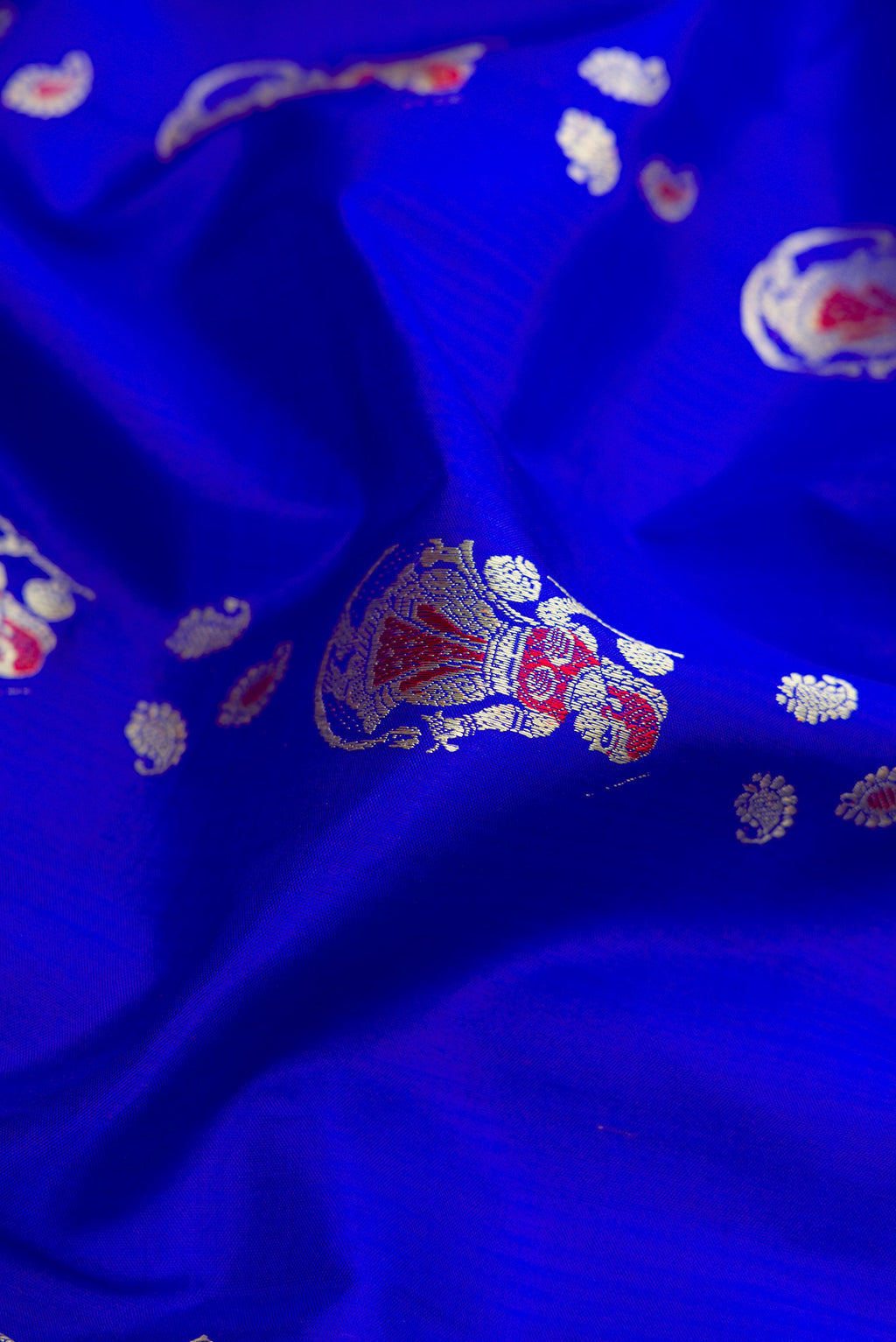 Close up of Royal Blue Dual Tone Baluchari Silk Saree with Thread Butta on the body and Thread Border.  displaying folds