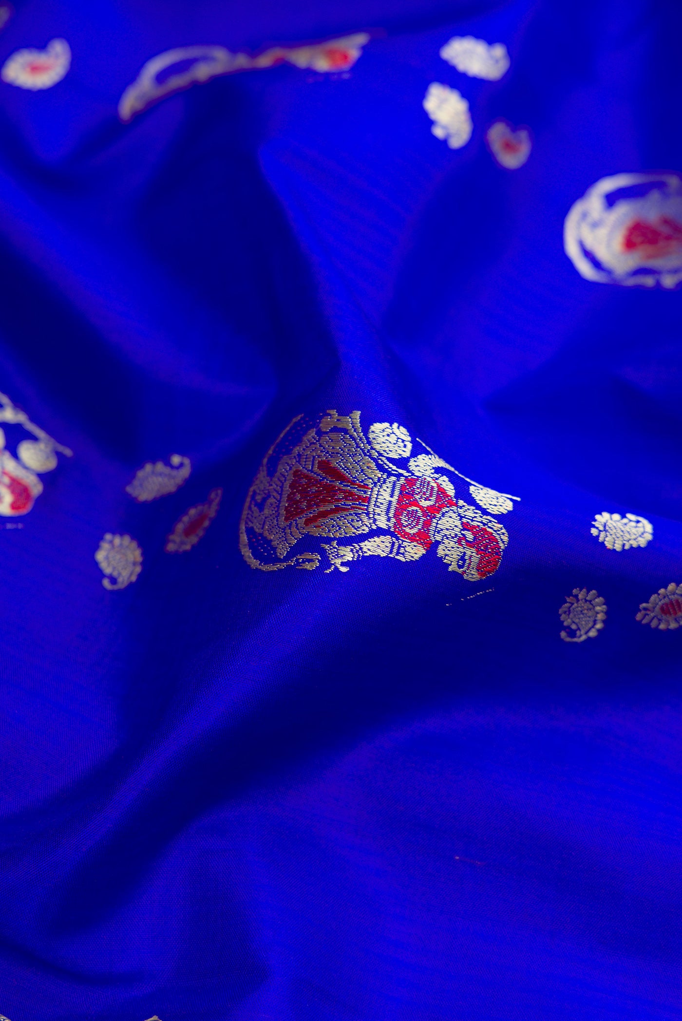 Close up of Royal Blue Dual Tone Baluchari Silk Saree with Thread Butta on the body and Thread Border.  displaying folds
