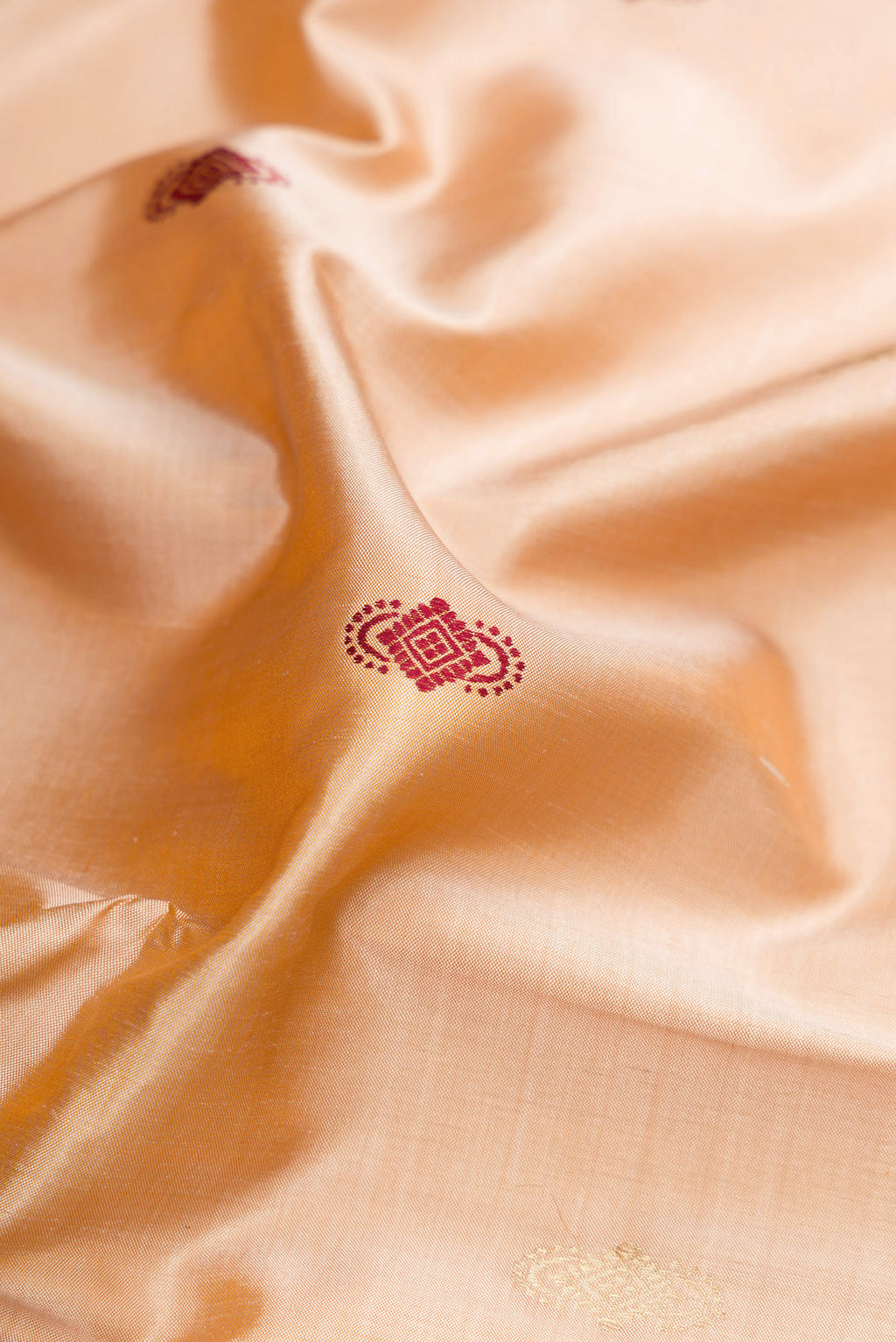 Close up of Beige Baluchari Silk Saree with Zari And Thread Butta on the body and Zari And Thread Border.  displaying folds