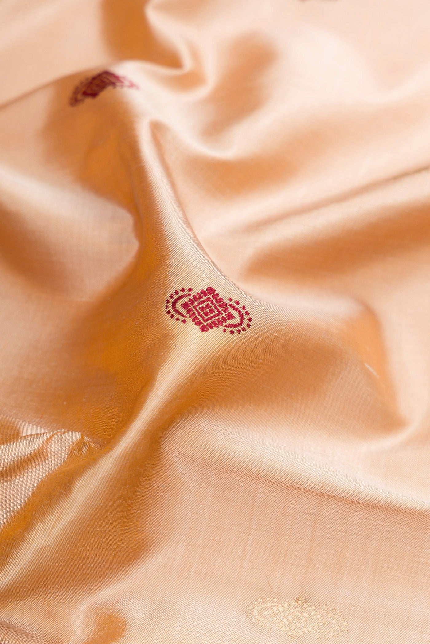 Close up of Beige Baluchari Silk Saree with Zari And Thread Butta on the body and Zari And Thread Border.  displaying folds