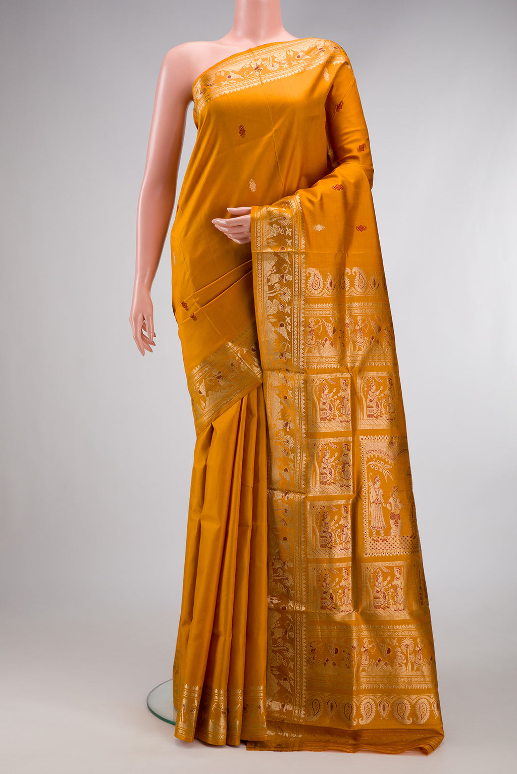 Mustard Baluchari Silk Saree with Zari And Thread Butta on the body and Zari And Thread Border.  displayed on a mannequin