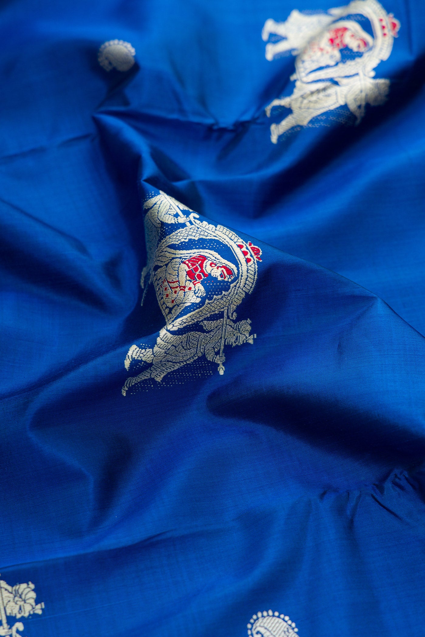Close up of Royal Blue Baluchari Silk Saree with Thread Butta on the body and Thread Border.  displaying folds