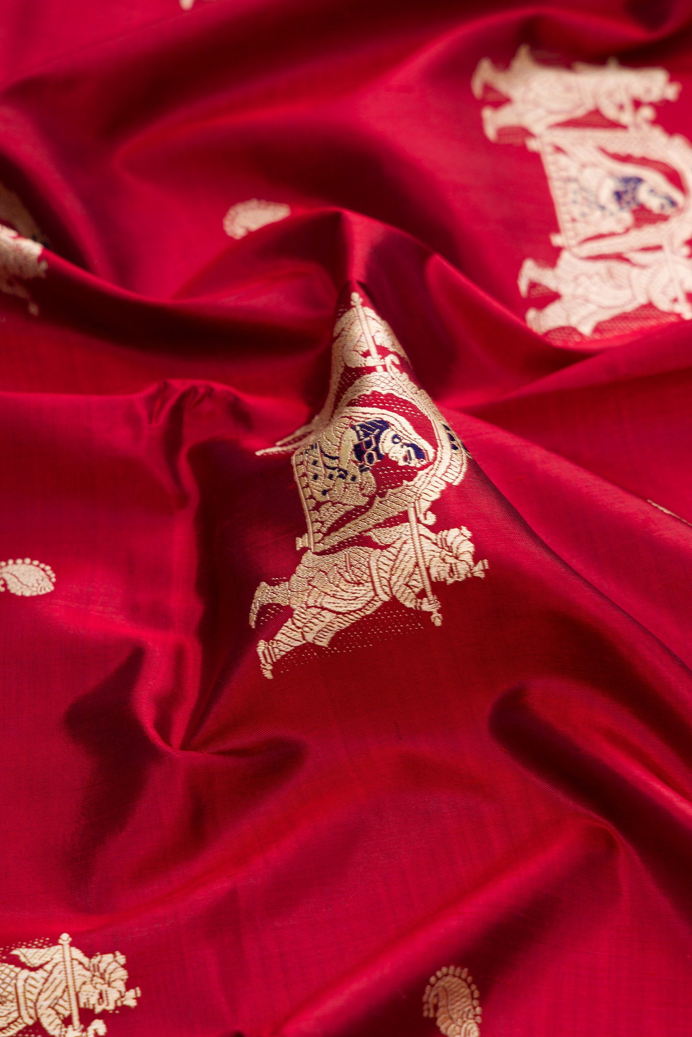 Close up of Maroon Baluchari Silk Saree with Thread Butta on the body and Thread Border.  displaying folds