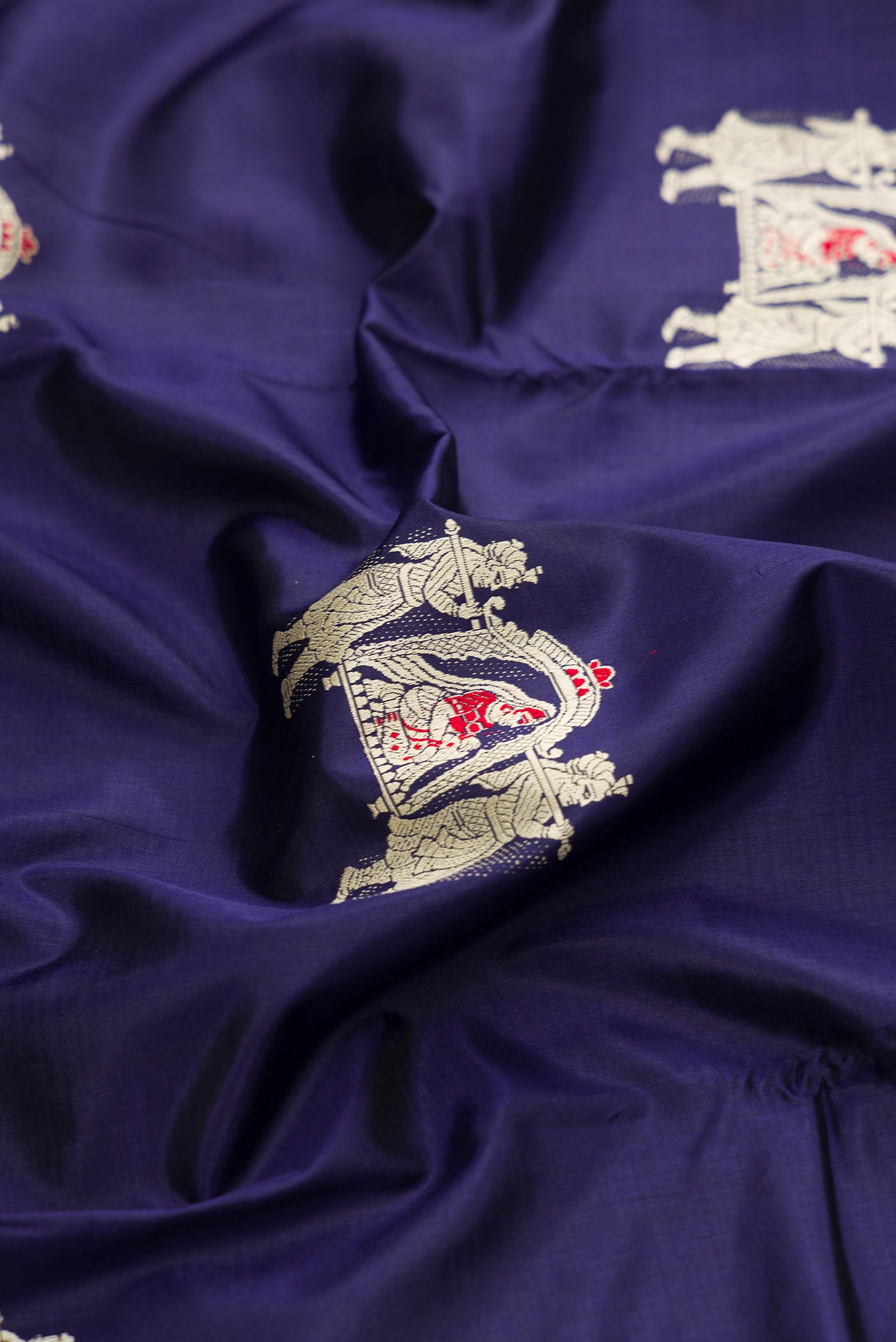 Close up of Navy Blue Baluchari Silk Saree with Thread Butta on the body and Fancy Border.  displaying folds