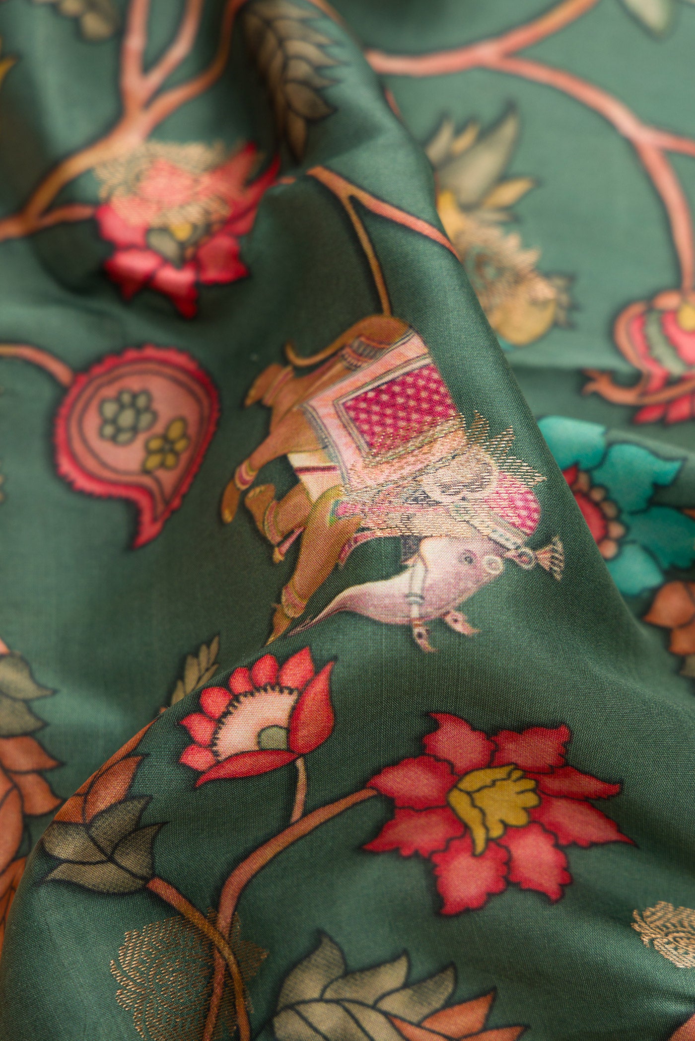 Close up of Green Kanjivaram Silk Saree with Floral Print on the body and Zari Border.  displaying folds