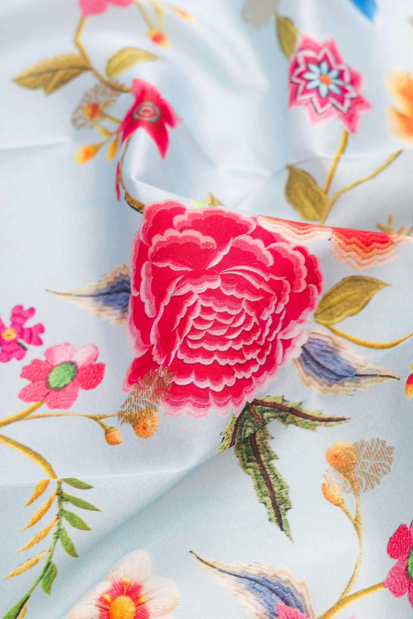 Close up of Light Blue Kanjivaram Silk Saree with Floral Print on the body and Zari Border.  displaying folds
