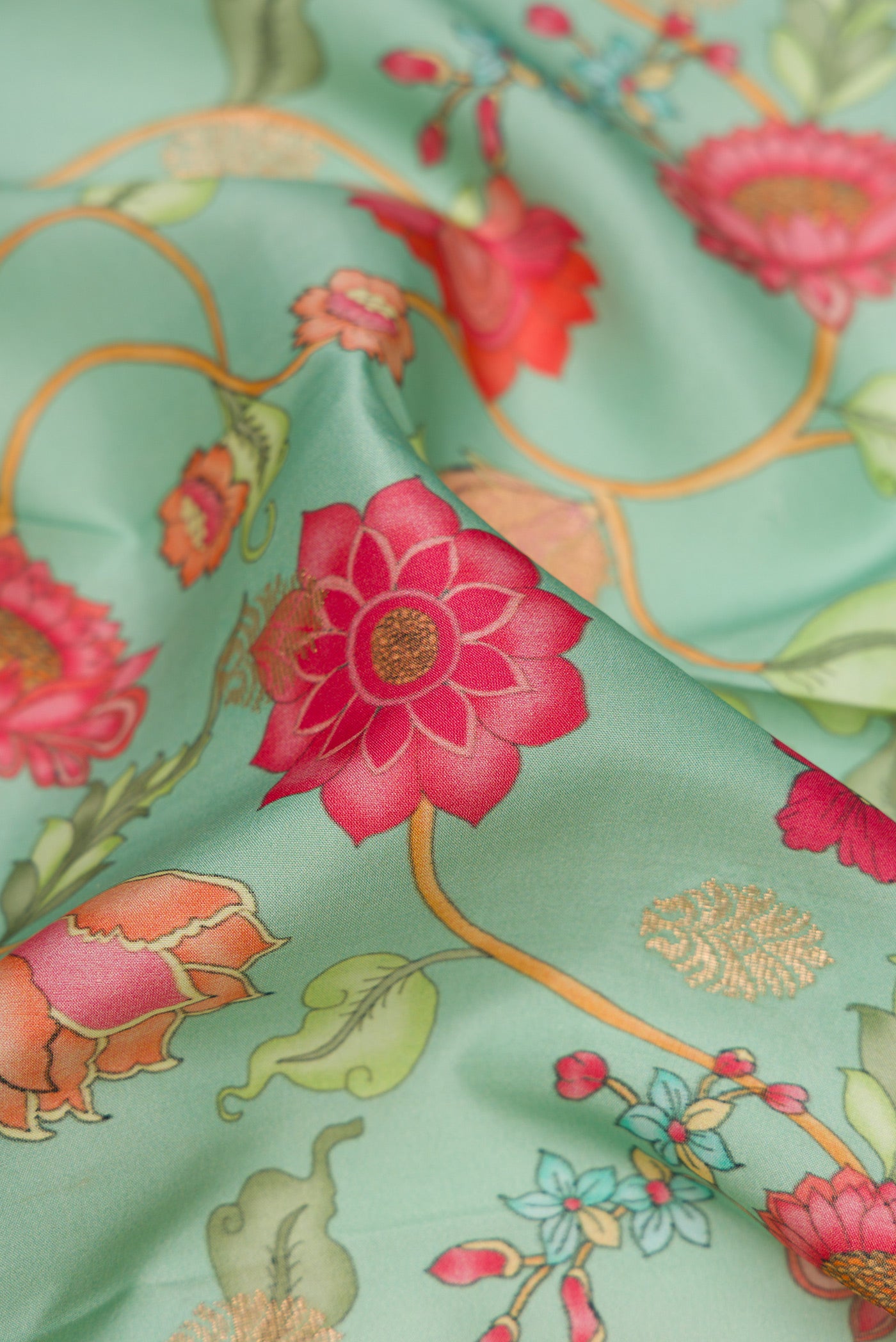 Close up of Sea Green Kanjivaram Silk Saree with Floral Print on the body and Zari Border.  displaying folds
