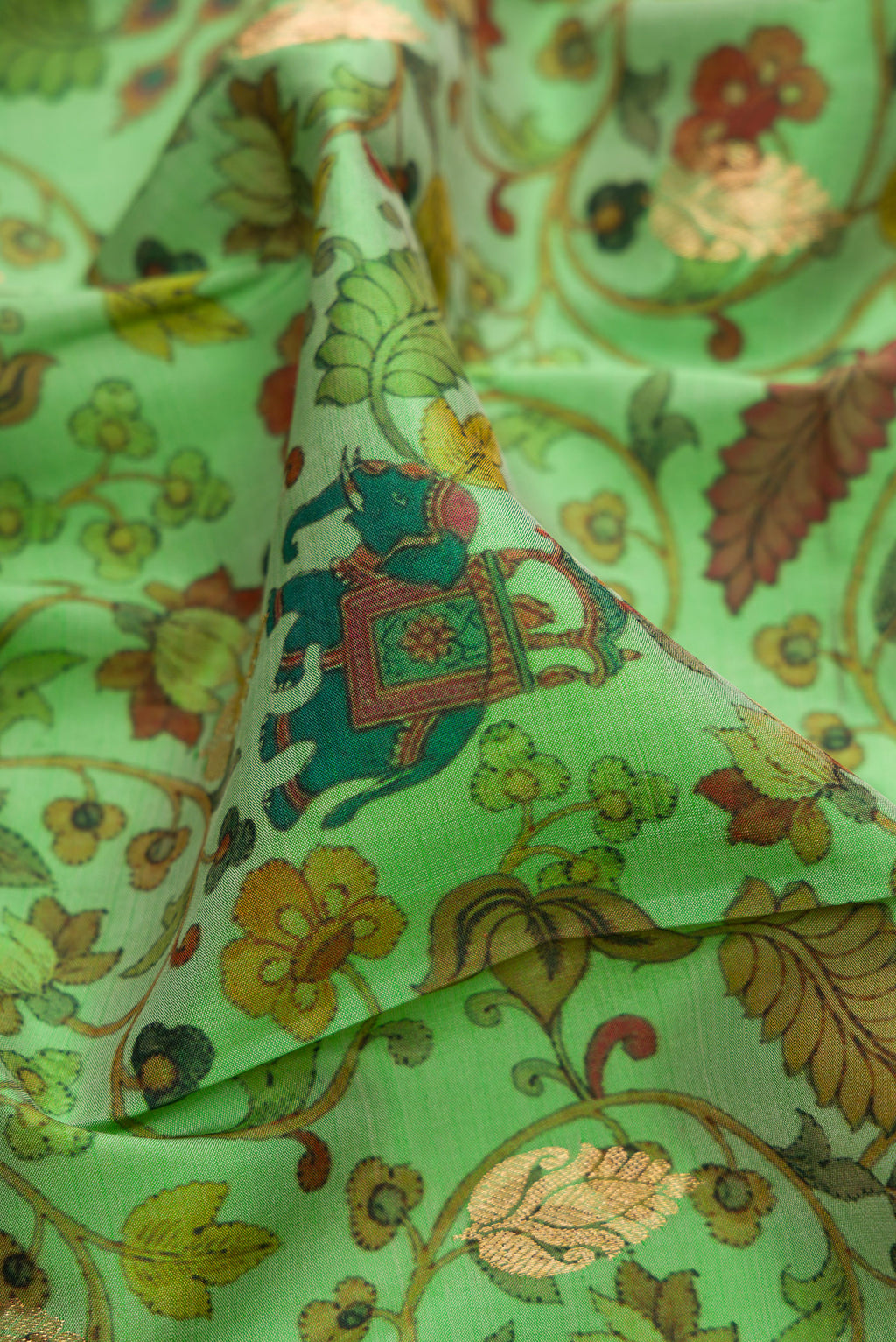 Close up of Green Kanjivaram Silk Saree with Floral Print on the body and Zari Border.  displaying folds