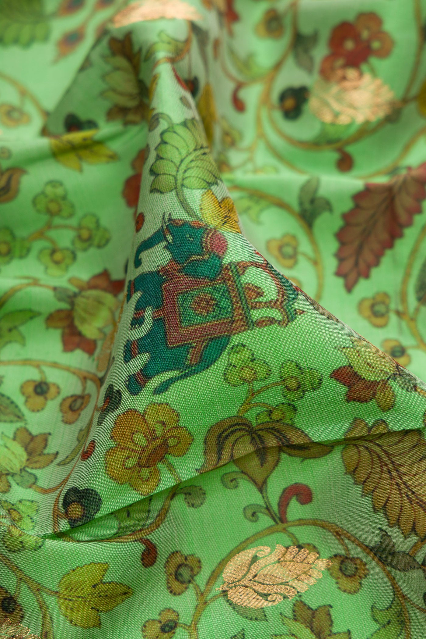 Close up of Green Kanjivaram Silk Saree with Floral Print on the body and Zari Border.  displaying folds