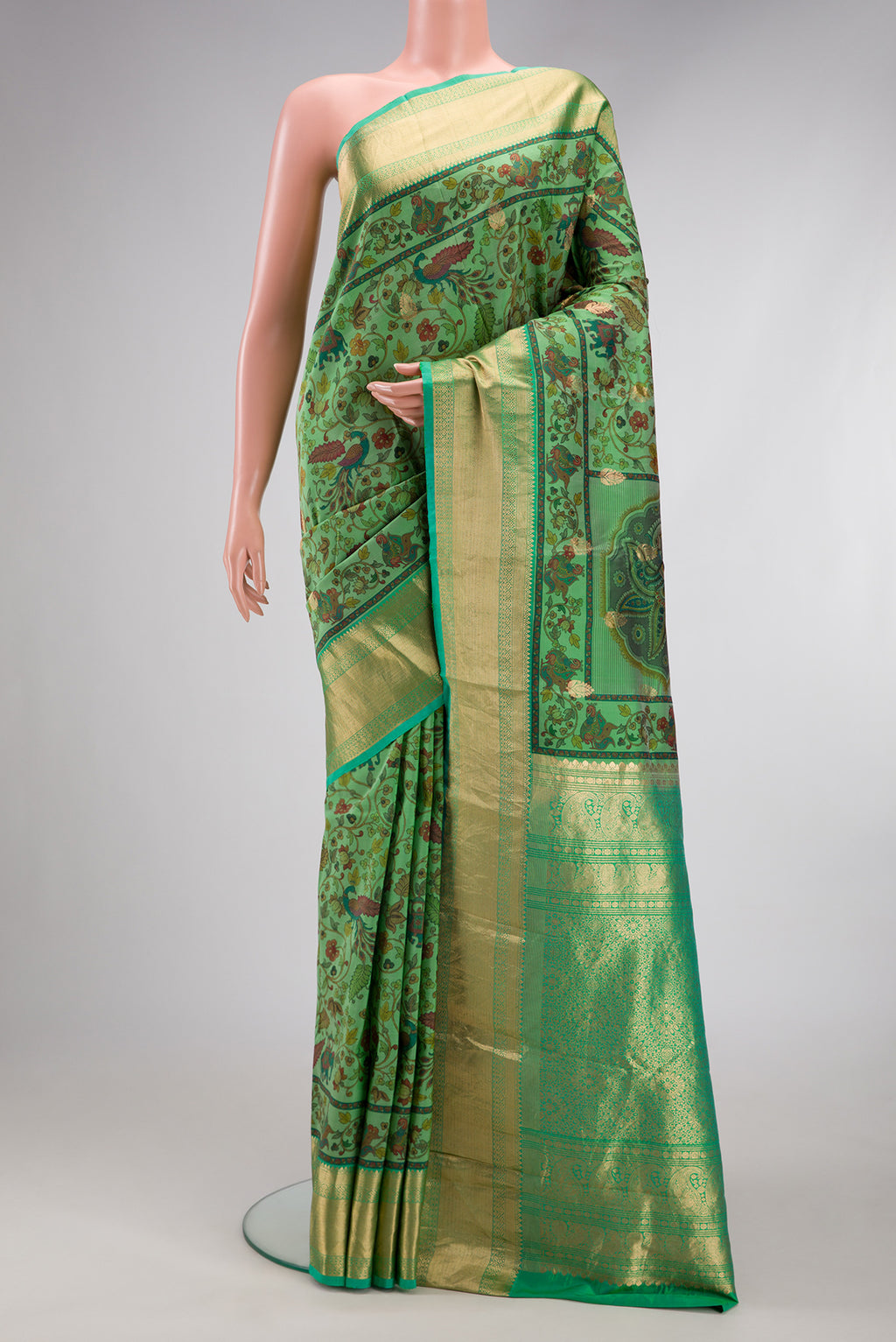 Green Kanjivaram Silk Saree with Floral Print on the body and Zari Border.  displayed on a mannequin