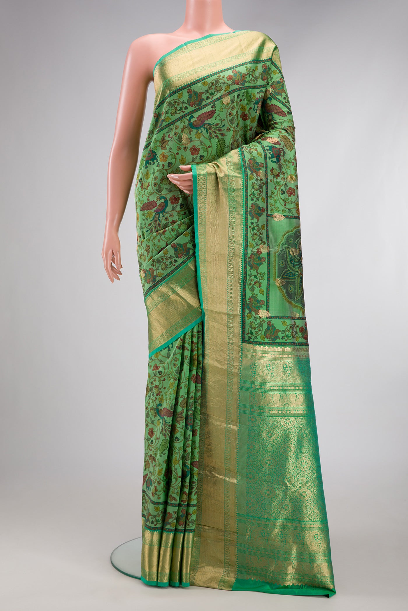 Green Kanjivaram Silk Saree with Floral Print on the body and Zari Border.  displayed on a mannequin