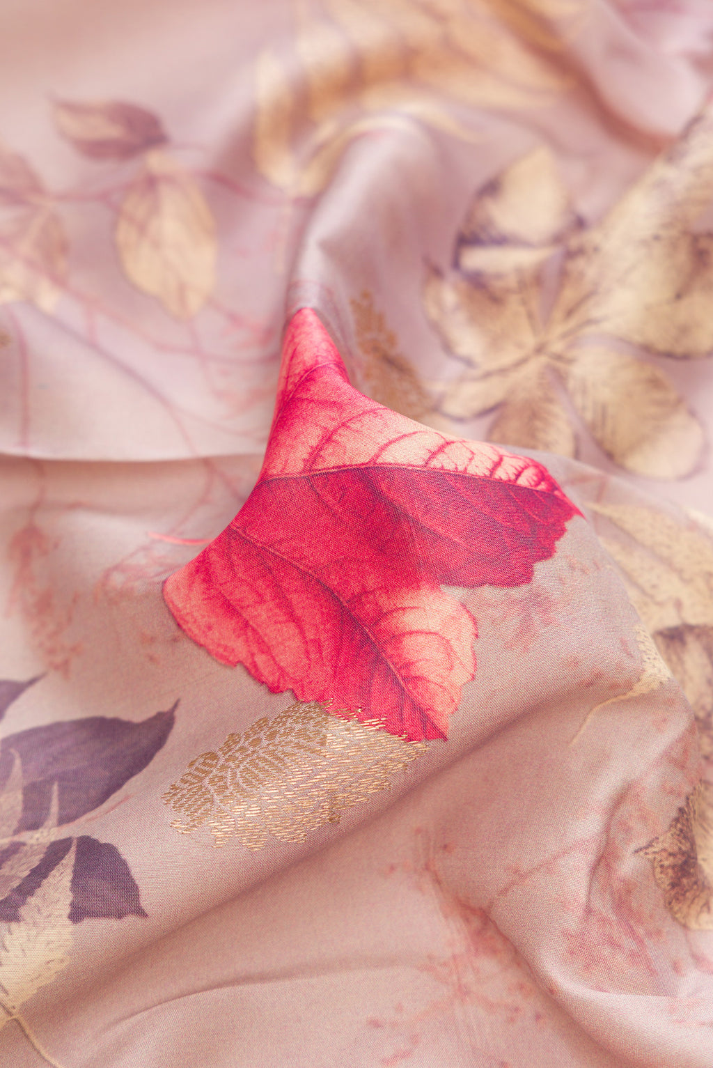Close up of Rose Gold Kanjivaram Silk Saree with Floral Print on the body and Zari Border.  displaying folds