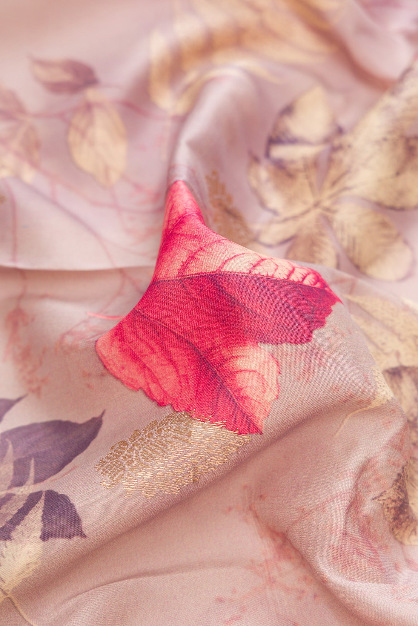 Close up of Rose Gold Kanjivaram Silk Saree with Floral Print on the body and Zari Border.  displaying folds