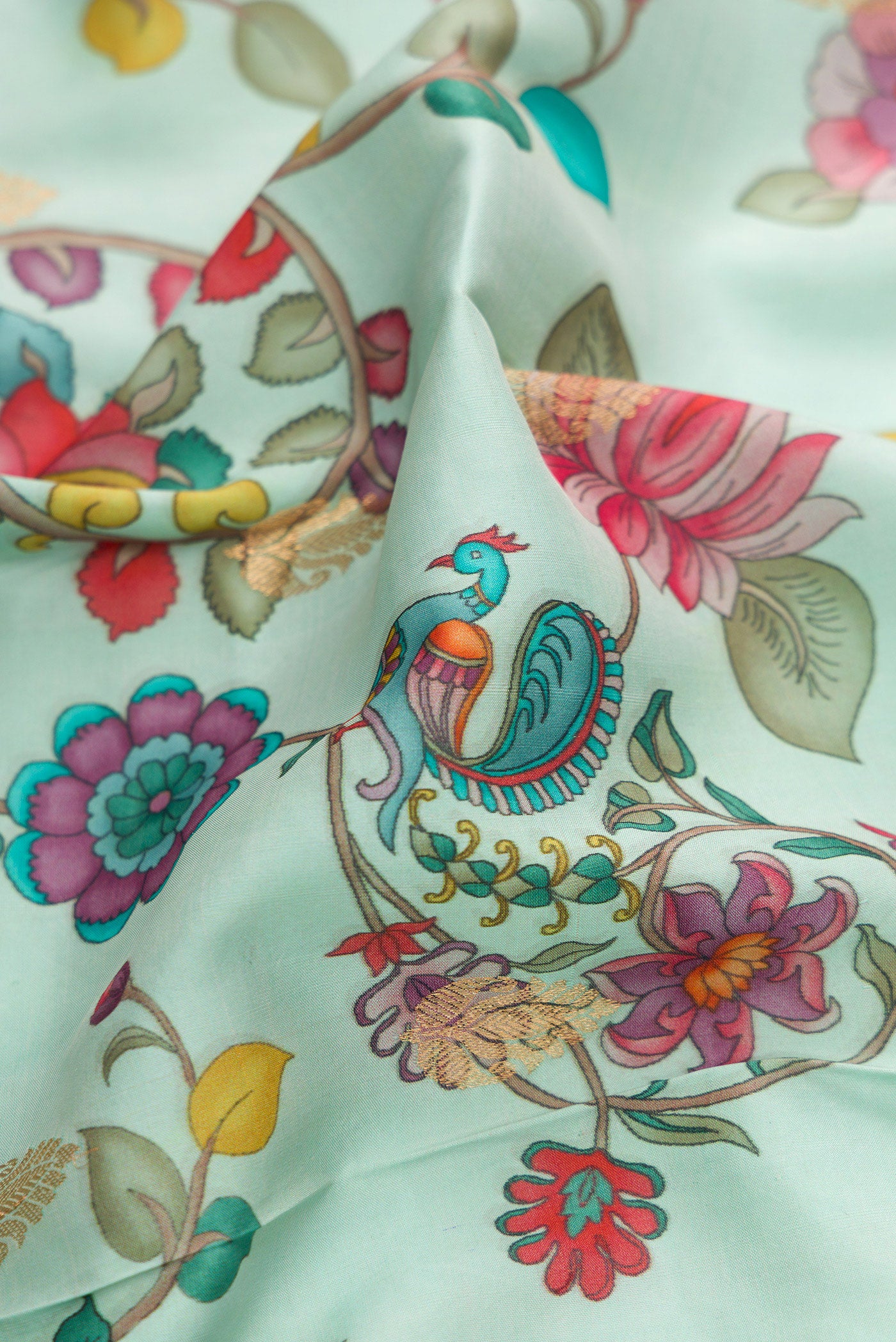Close up of Light Blue Kanjivaram Silk Saree with Floral Print on the body and Zari Border.  displaying folds