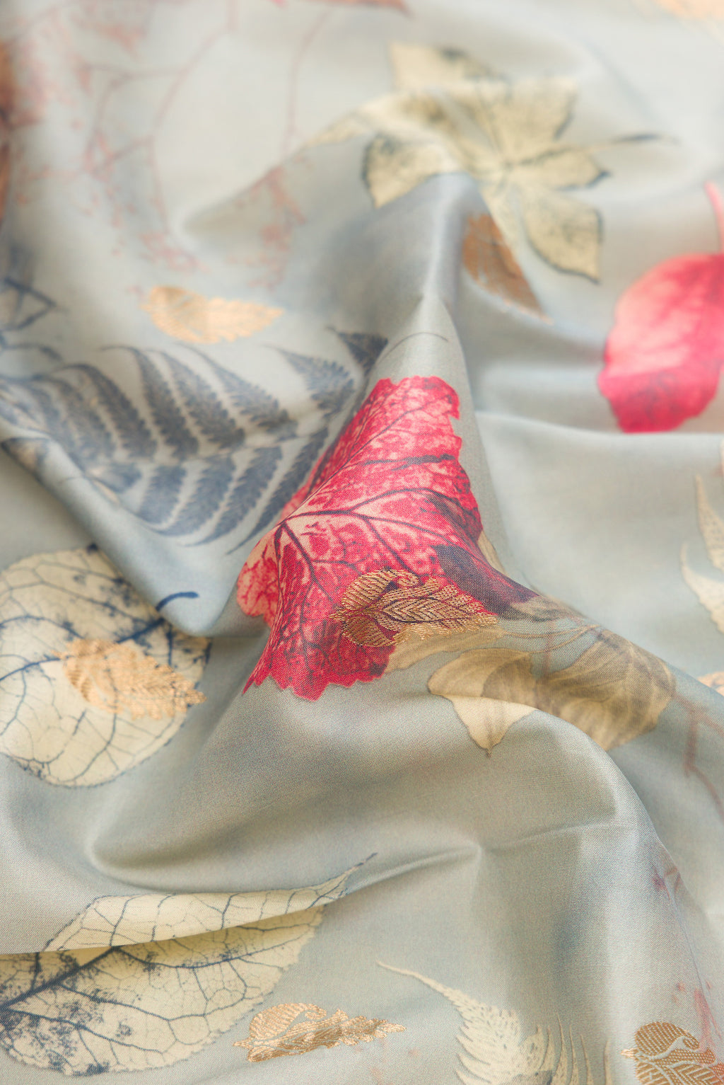 Close up of Grey Kanjivaram Silk Saree with Floral Print on the body and Zari Border.  displaying folds