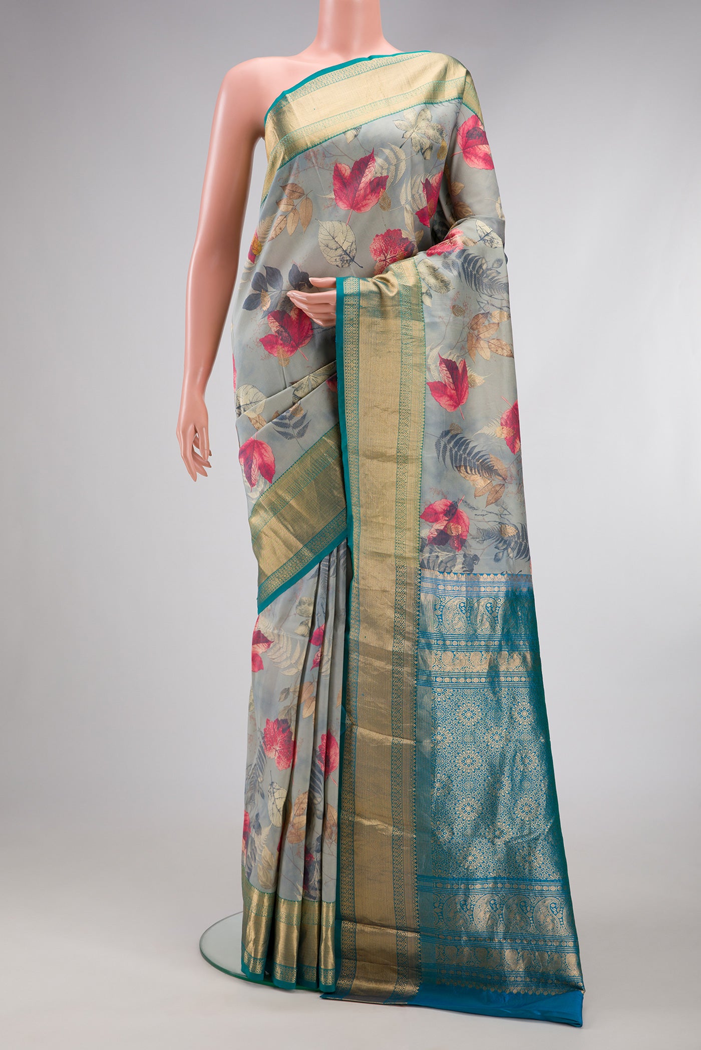 Grey Kanjivaram Silk Saree with Floral Print on the body and Zari Border.  displayed on a mannequin