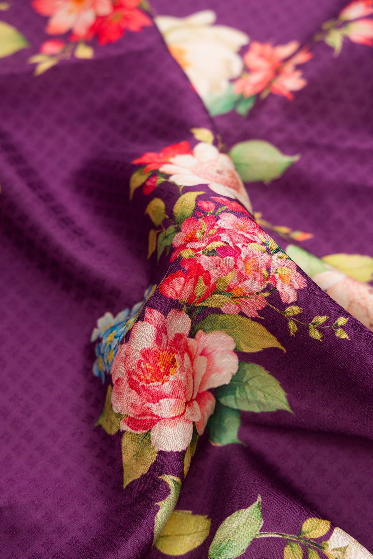 Close up of Purple Kanchipuram Silk Saree with Floral Print on the body and Zari Border.  displaying folds