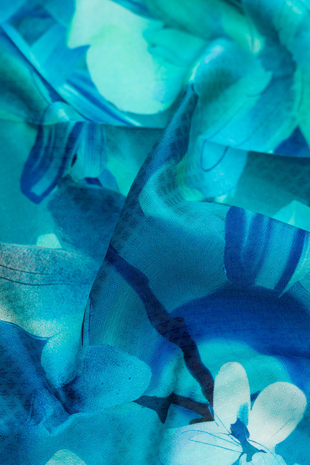 Close up of Sky Blue Kanchipuram Silk Saree with Floral Print on the body and Thread Border.  displaying folds