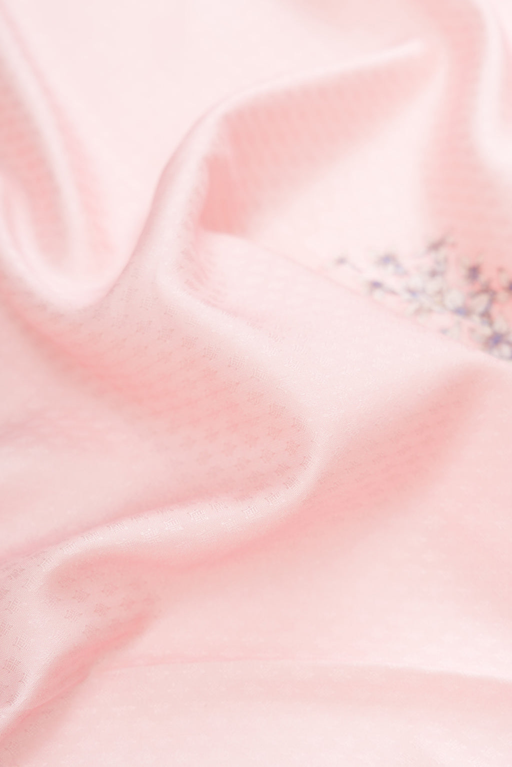 Close up of Rose pink Kanchipuram Silk Saree with Floral Print on the body and Zari Border.  displaying folds