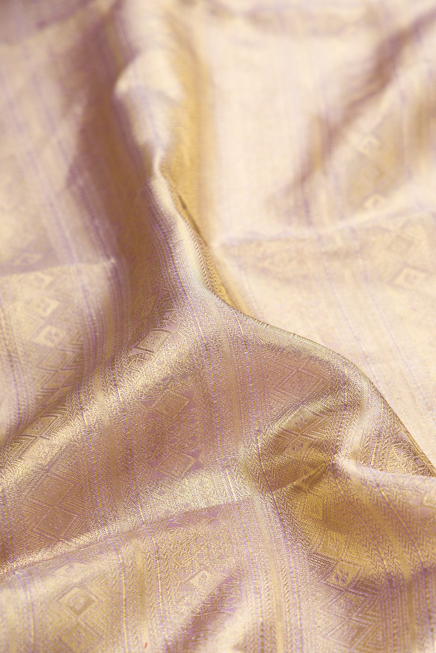 Close up of Gold Dual Tone Kanchipuram Tissue Silk Saree with Zari Brocade on the body and Zari Border.  displaying folds