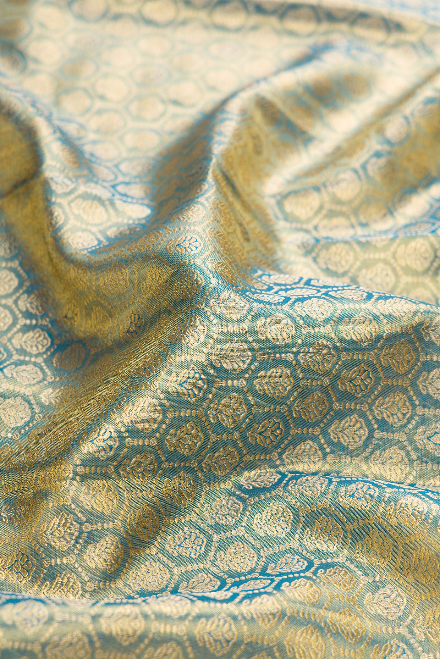 Close up of Light Blue Dual Tone Kanchipuram Tissue Silk Saree with Zari Brocade on the body and Zari Border.  displaying folds