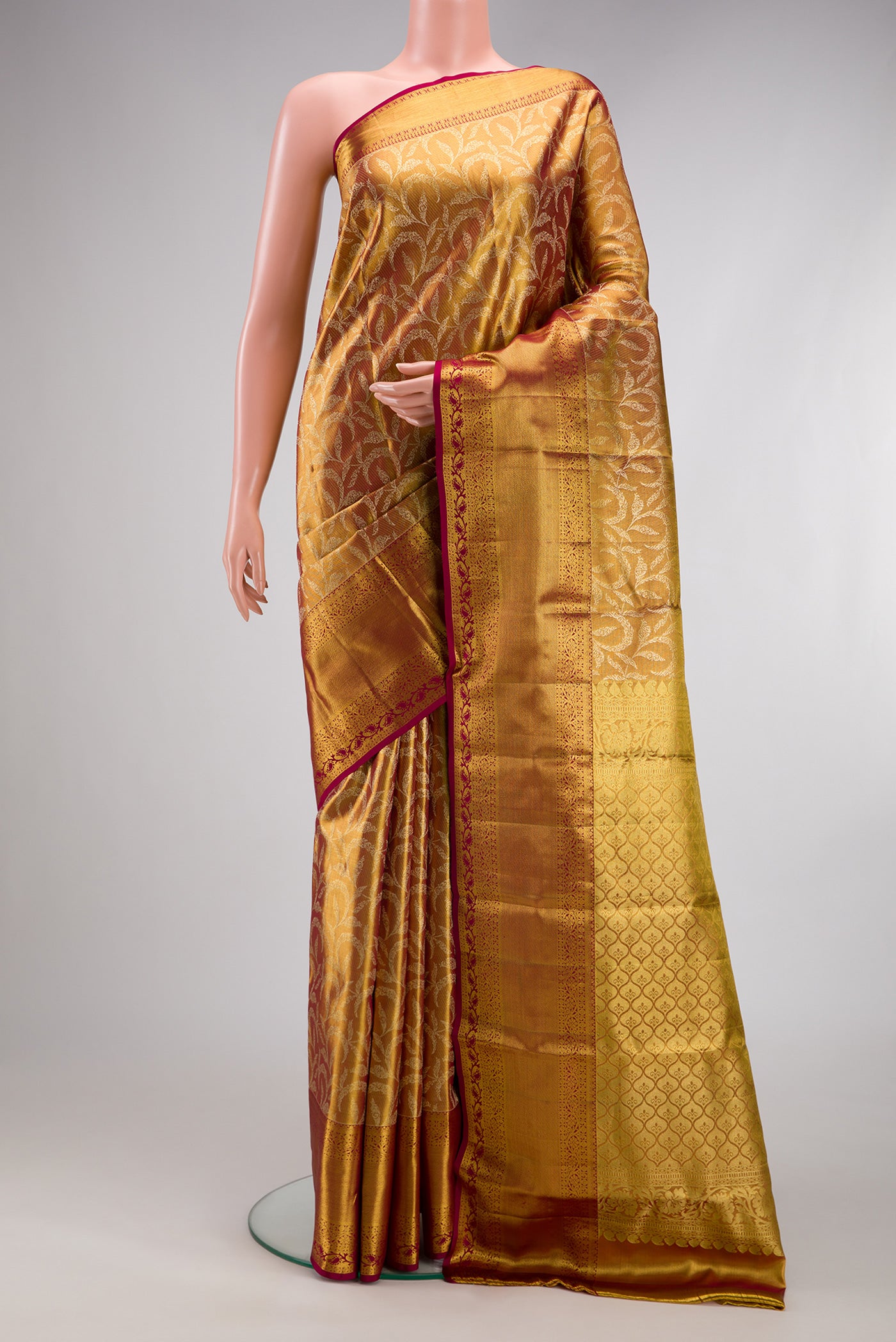 Gold Dual Tone Kanchipuram Tissue Silk Saree with Zari Brocade on the body and Fancy Border.  displayed on a mannequin