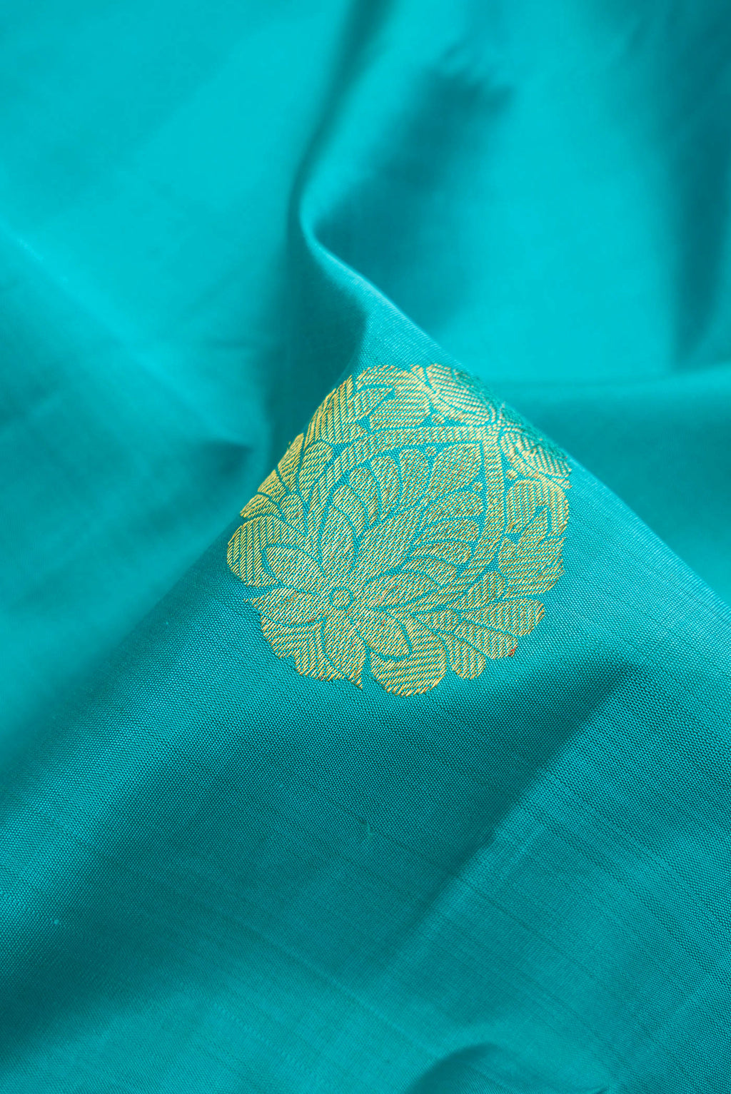 Close up of Sky Blue Kanjivaram Silk Saree with Zari Butta on the body and Zari Border.  displaying folds