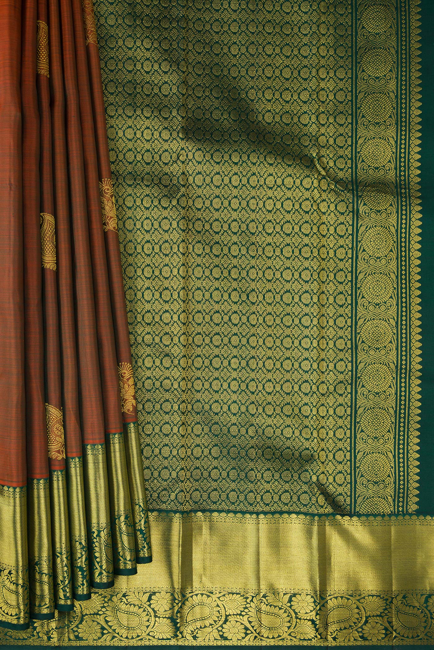Pleats and pallu of Rust Kanjivaram Silk Saree with Zari Butta on the body and Zari Border. 
