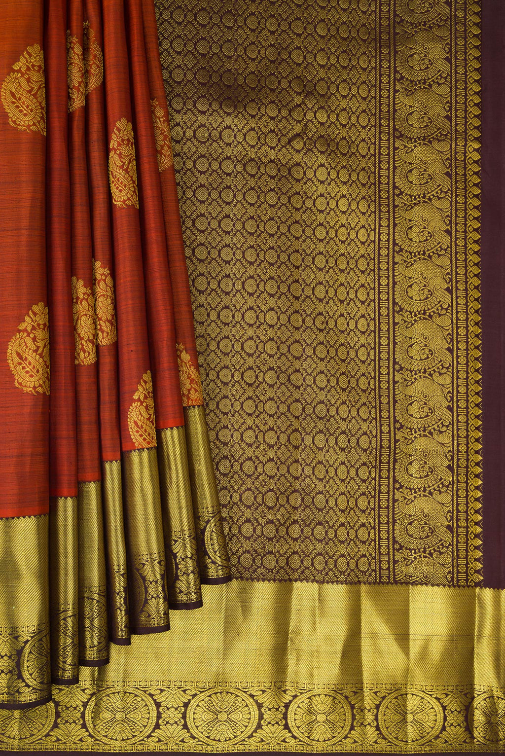 Pleats and pallu of Brick Orange Kanjivaram Silk Saree with Zari Butta on the body and Zari Border. 