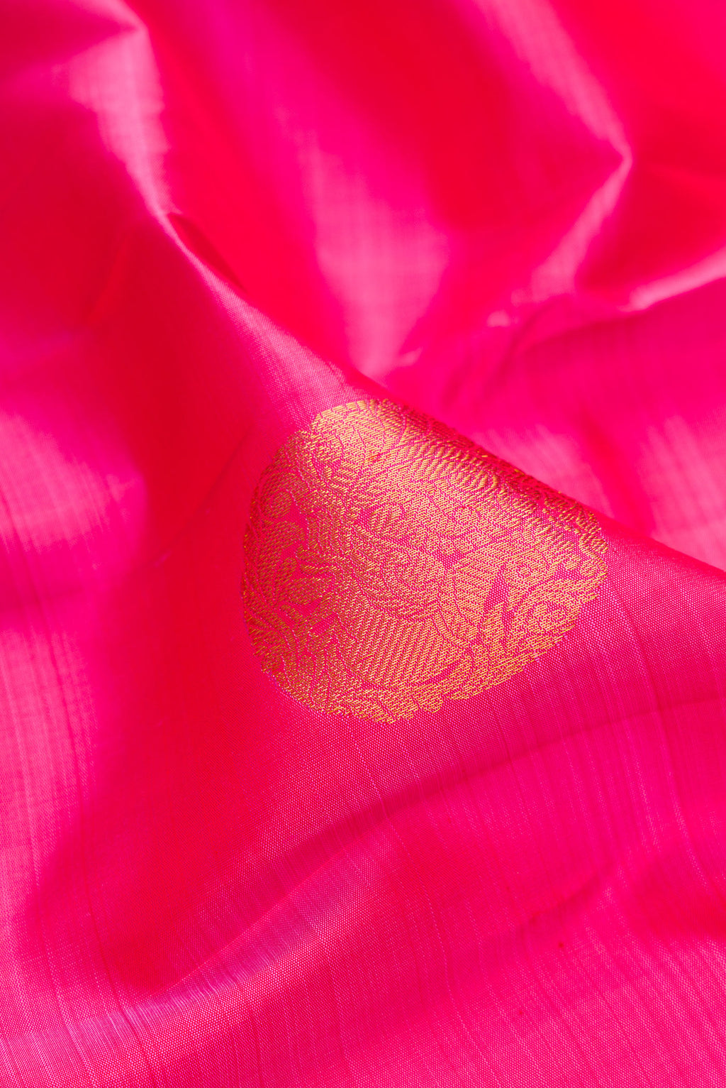 Close up of Pink Kanjivaram Silk Saree with Zari Butta on the body and Zari Border.  displaying folds