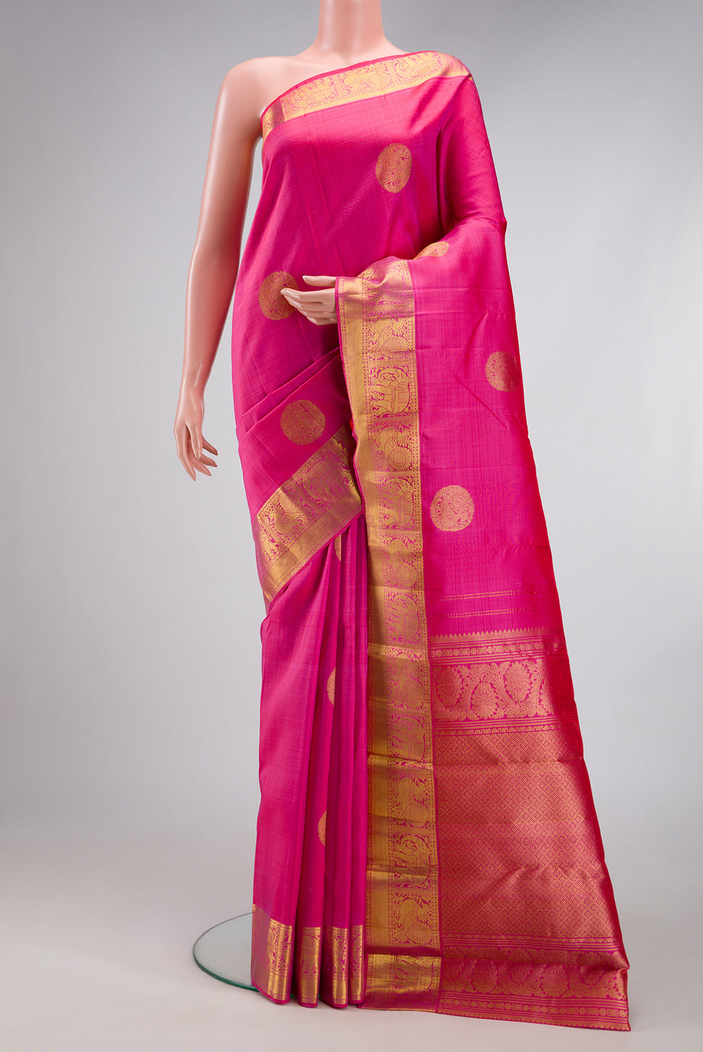 Pink Kanjivaram Silk Saree with Zari Butta on the body and Zari Border.  displayed on a mannequin