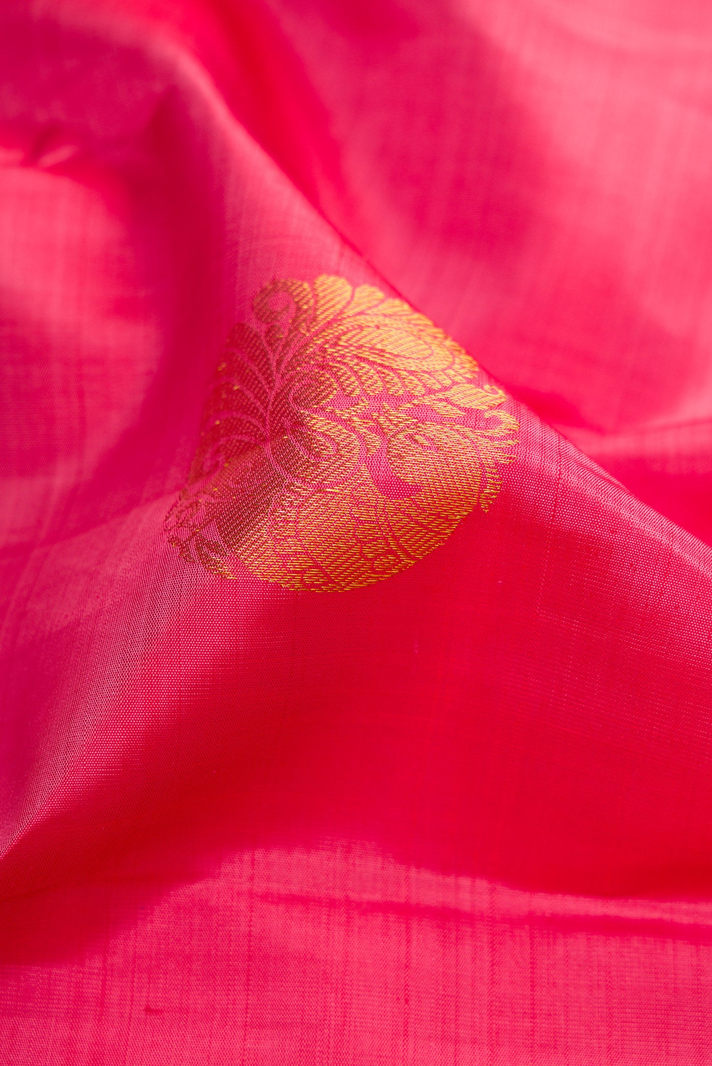 Close up of Pink Kanjivaram Silk Saree with Zari Butta on the body and Zari Border.  displaying folds