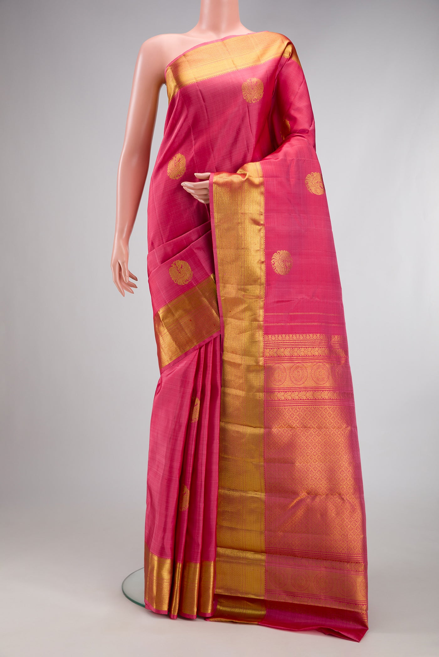 Pink Kanjivaram Silk Saree with Zari Butta on the body and Zari Border.  displayed on a mannequin