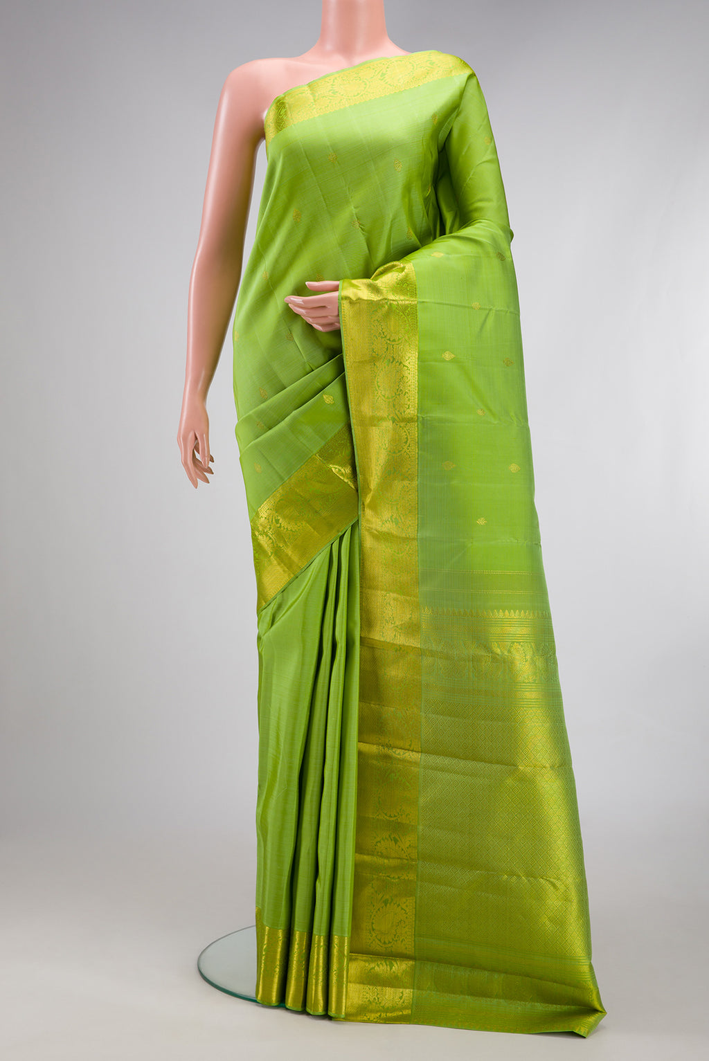 Pista Green Kanjivaram Silk Saree with Zari Butta on the body and Zari Border.  displayed on a mannequin