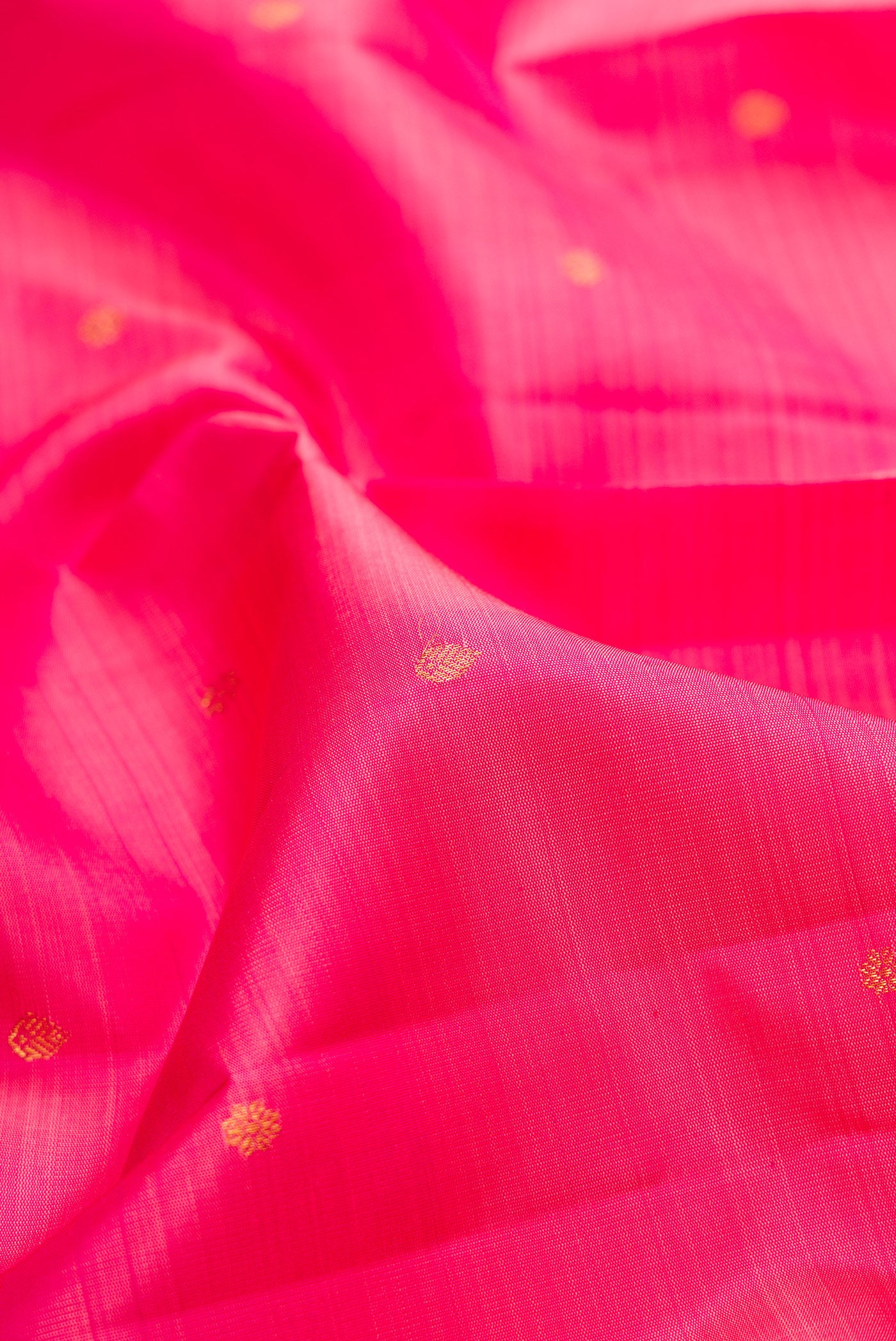 Close up of Pink Kanjivaram Silk Saree with Zari Butta on the body and Zari Border.  displaying folds