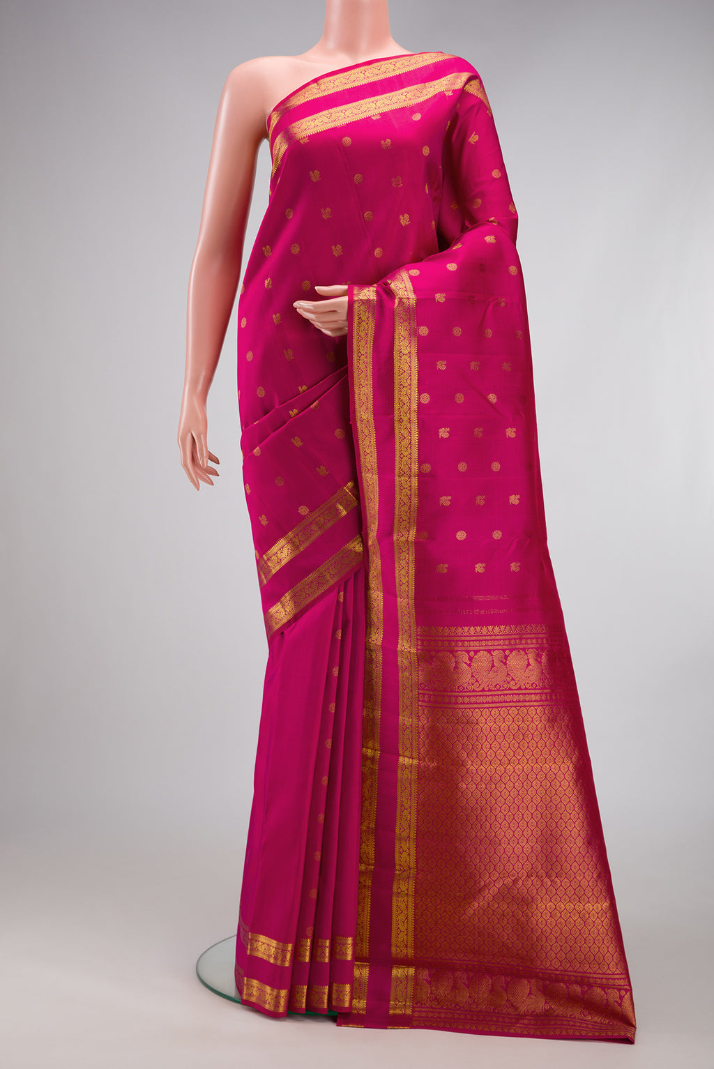 Rani Pink Kanjivaram Silk Saree with Zari Butta on the body and Zari Border.  displayed on a mannequin