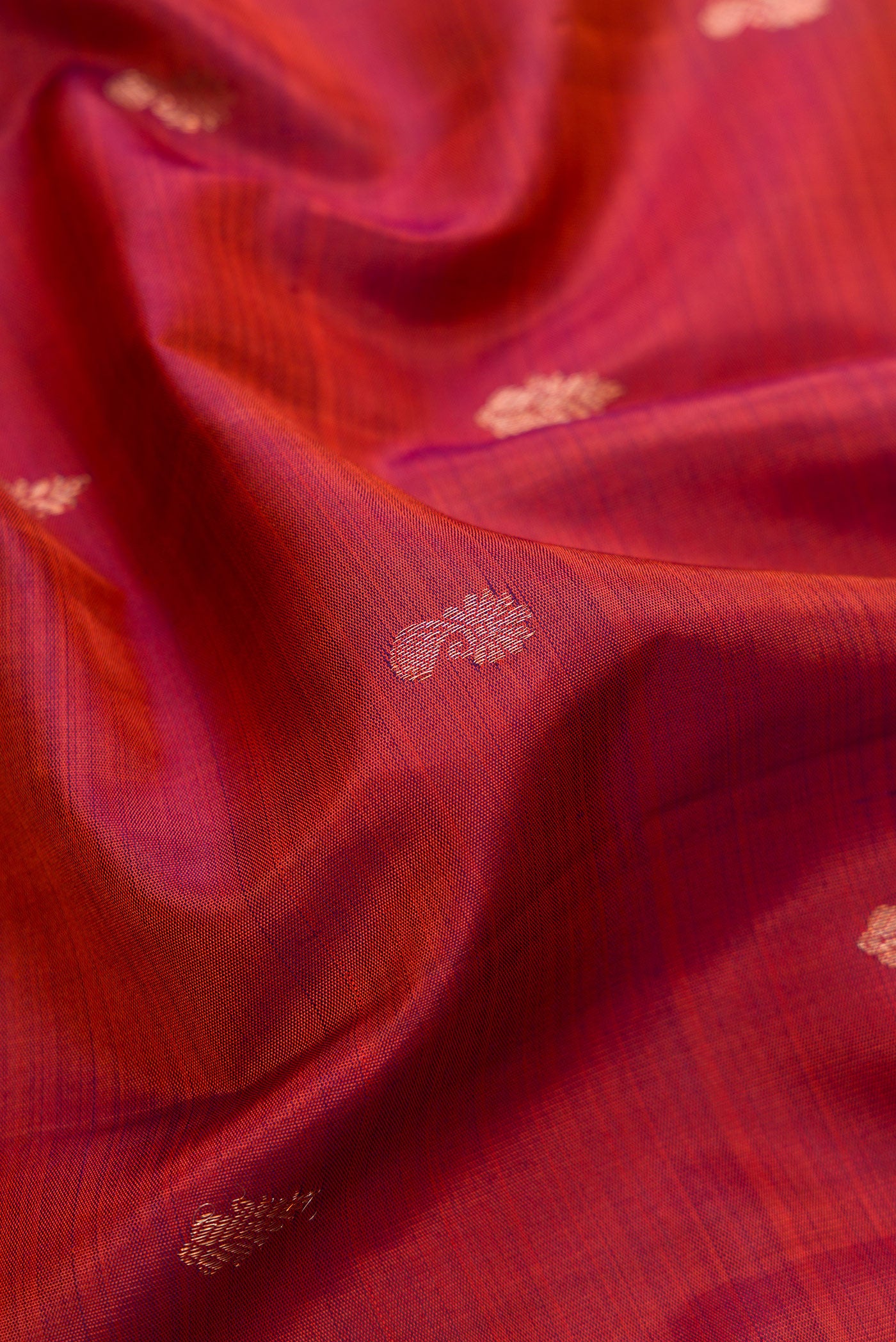 Close up of Orange with Magenta Color Kanjivaram Silk Saree with Zari Butta on the body and Zari Border.  displaying folds