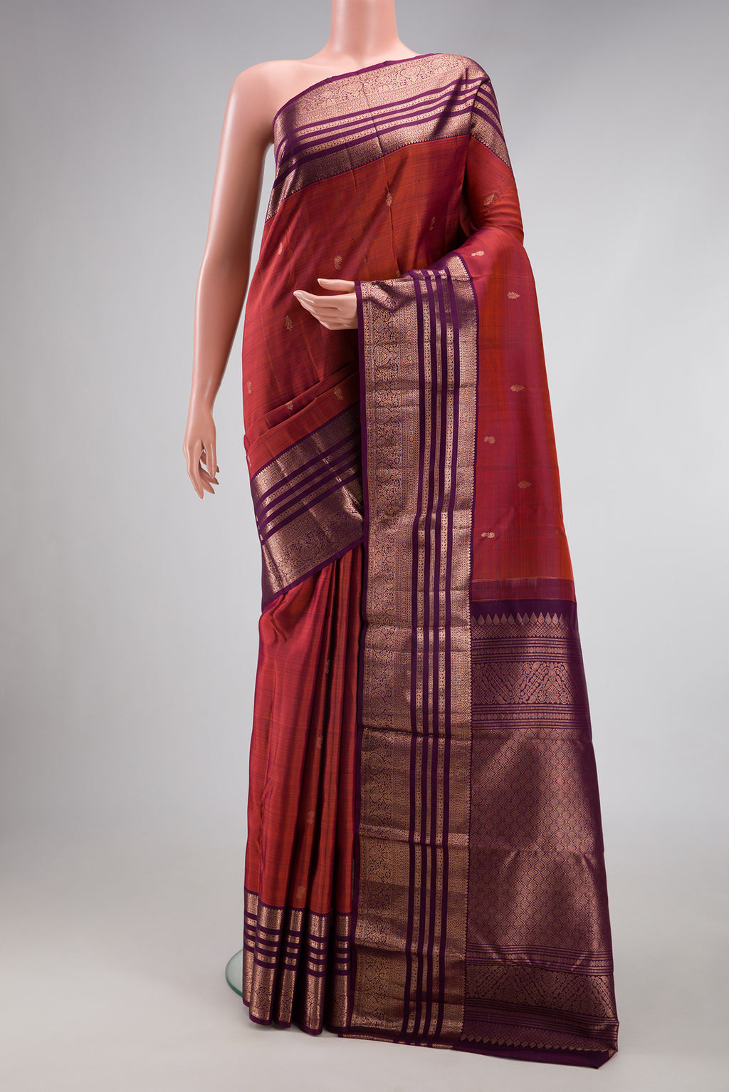 Orange with Magenta Color Kanjivaram Silk Saree with Zari Butta on the body and Zari Border.  displayed on a mannequin