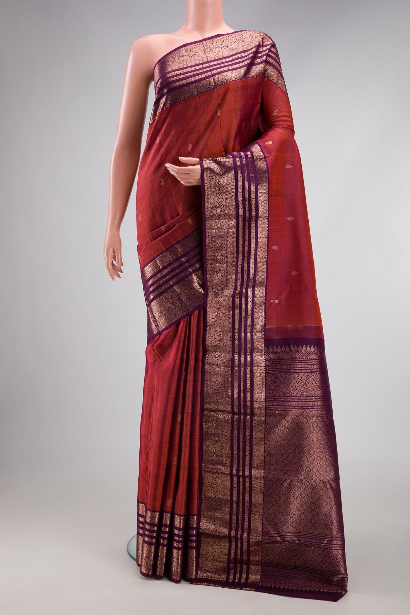 Orange with Magenta Color Kanjivaram Silk Saree with Zari Butta on the body and Zari Border.  displayed on a mannequin