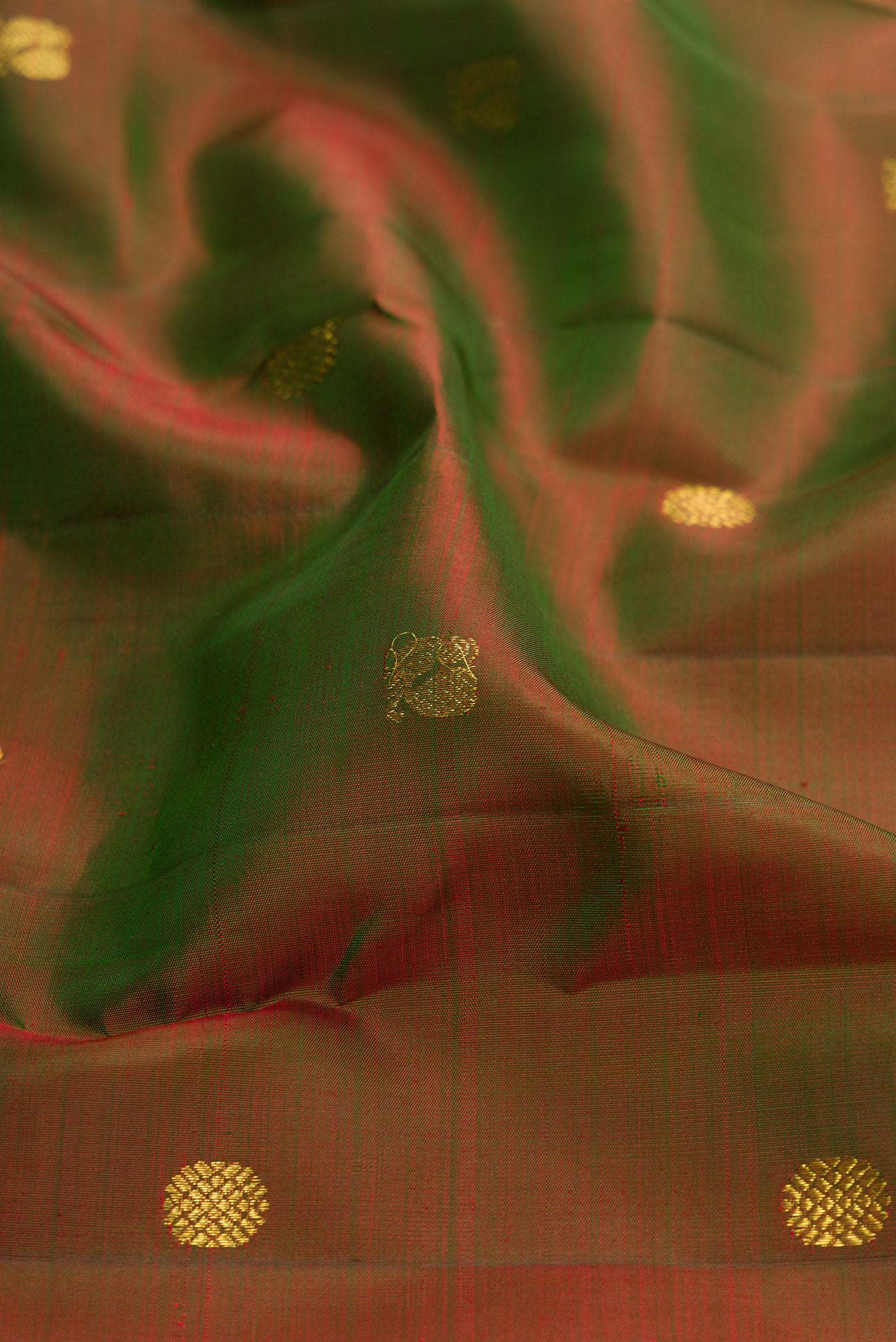 Close up of Mehandi Green Dual Tone Kanjivaram Silk Saree with Zari Butta on the body and Zari Border.  displaying folds
