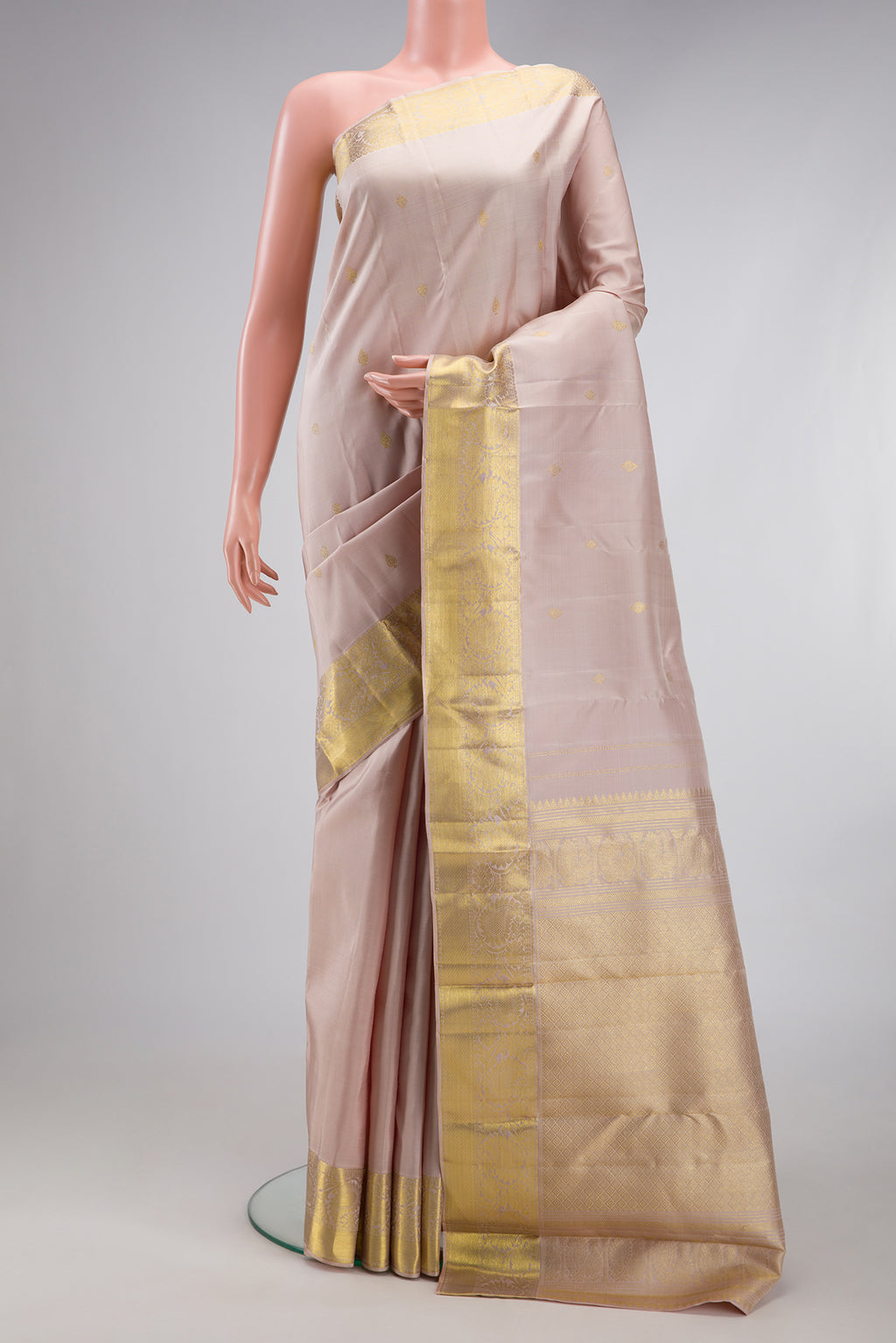 Rose Gold Kanjivaram Silk Saree with Zari Butta on the body and Zari Border.  displayed on a mannequin