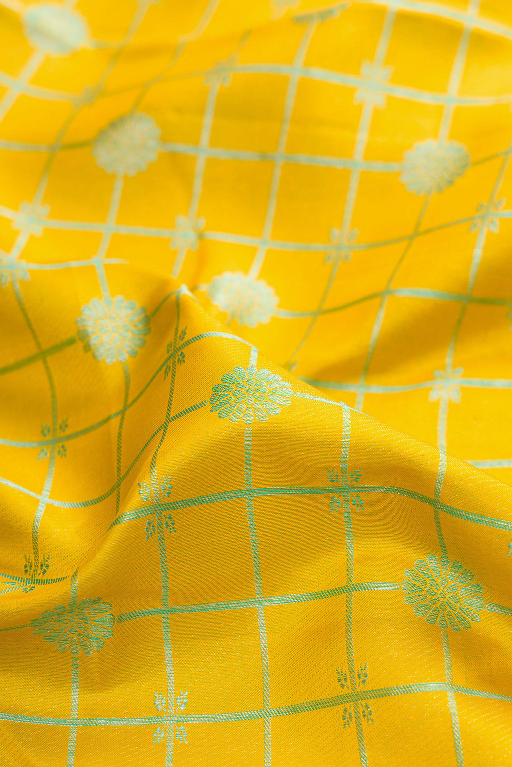 Close up of Pure Silk Yellow Kanjivaram Saree with Checked design on the body and Fancy Border.  displaying folds