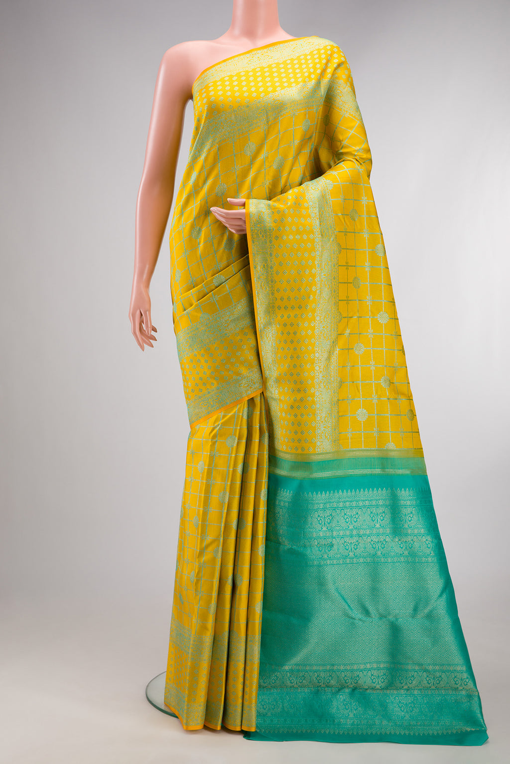 Pure Silk Yellow Kanjivaram Saree with Checked design on the body and Fancy Border.  displayed on a mannequin