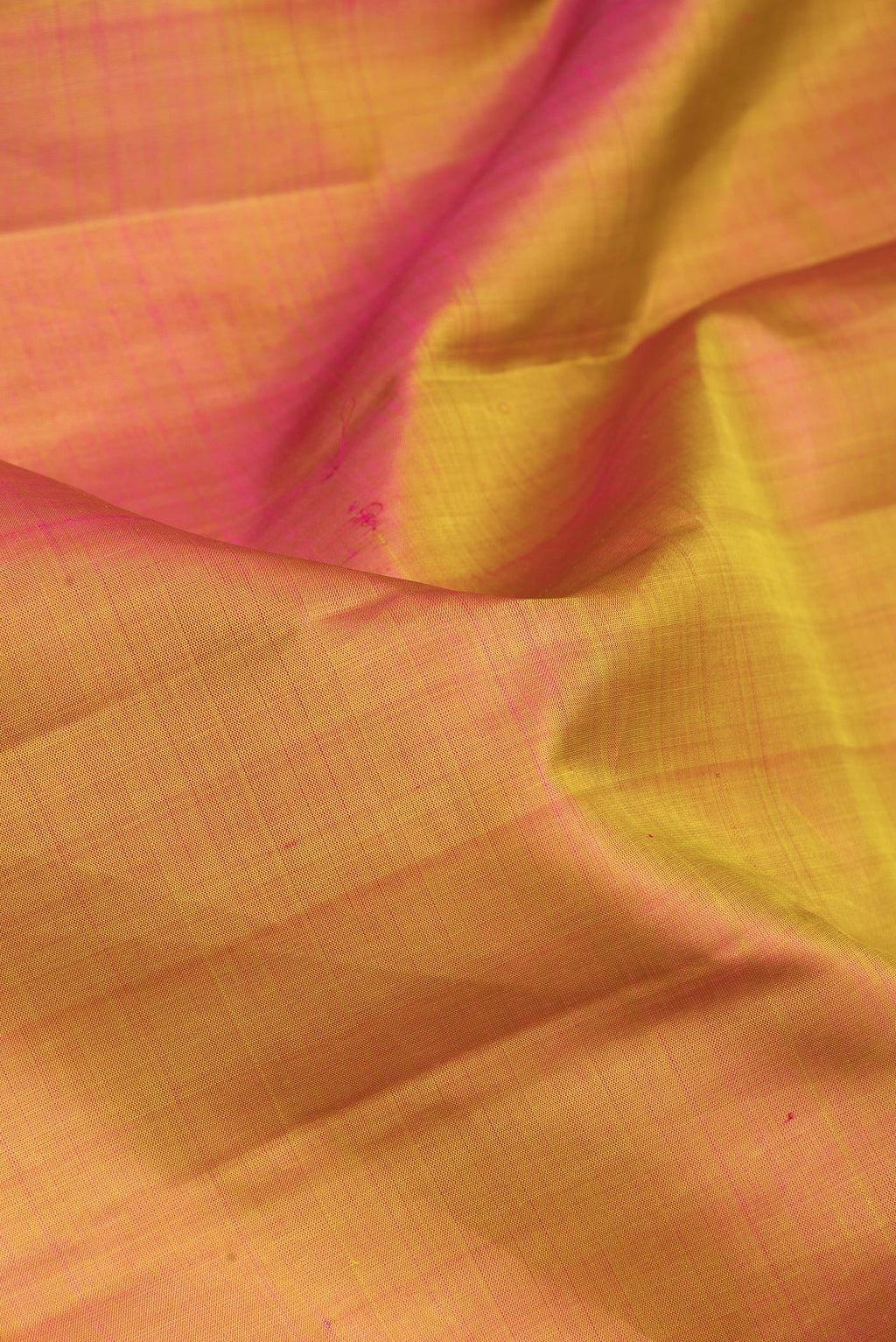 Close up of Mustard Dual Tone Kanjivaram Silk Saree with Plain Body and Zari Border.  displaying folds