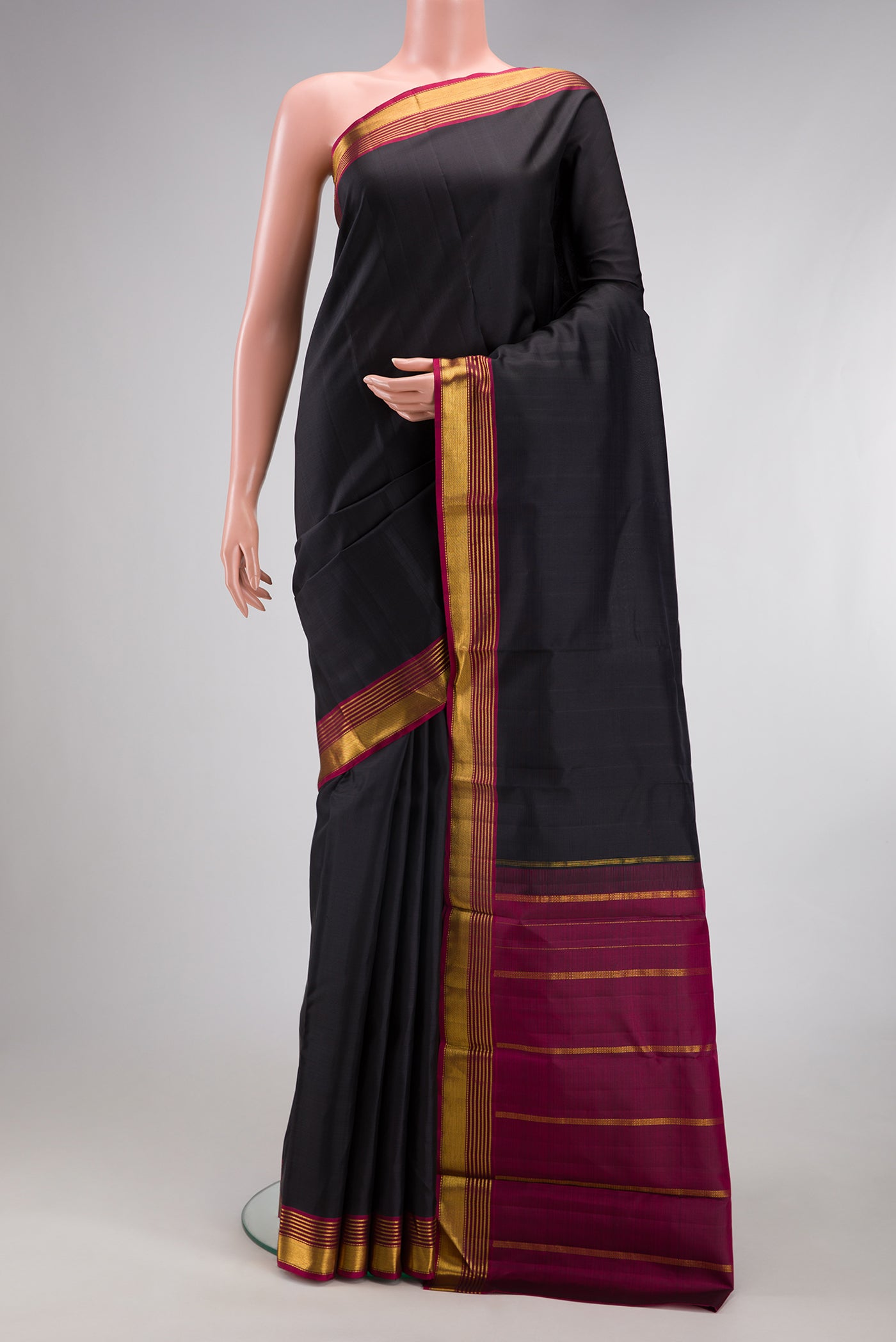 Black Kanjivaram Silk Saree with Plain Body and Zari Border.  displayed on a mannequin