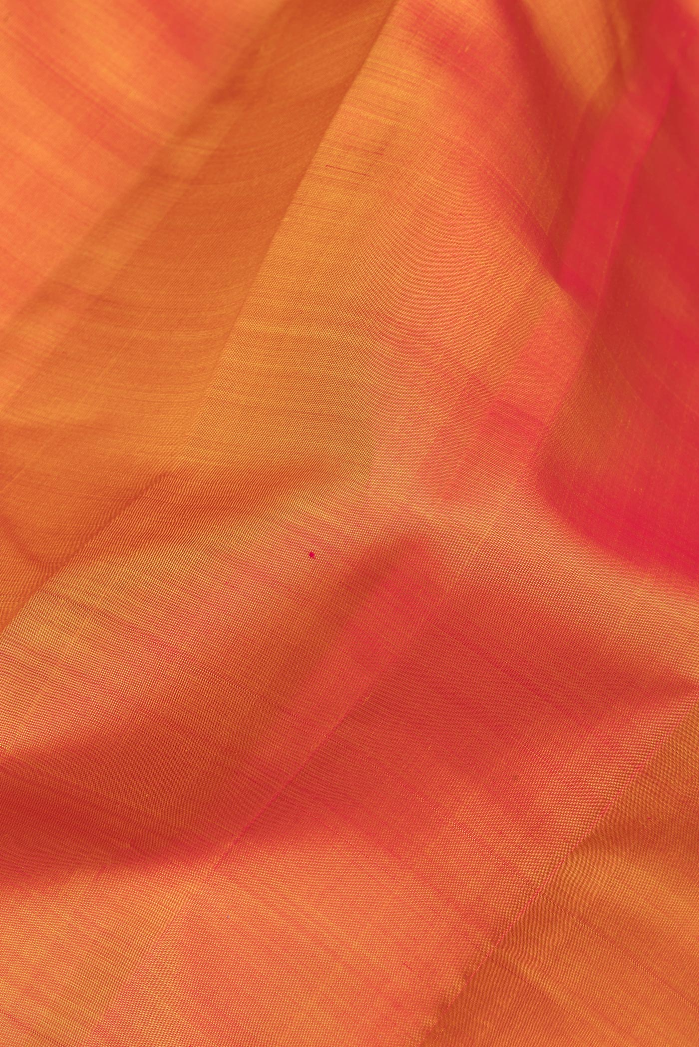 Close up of Orange Kanjivaram Silk Saree with Plain Body and Zari Border.  displaying folds
