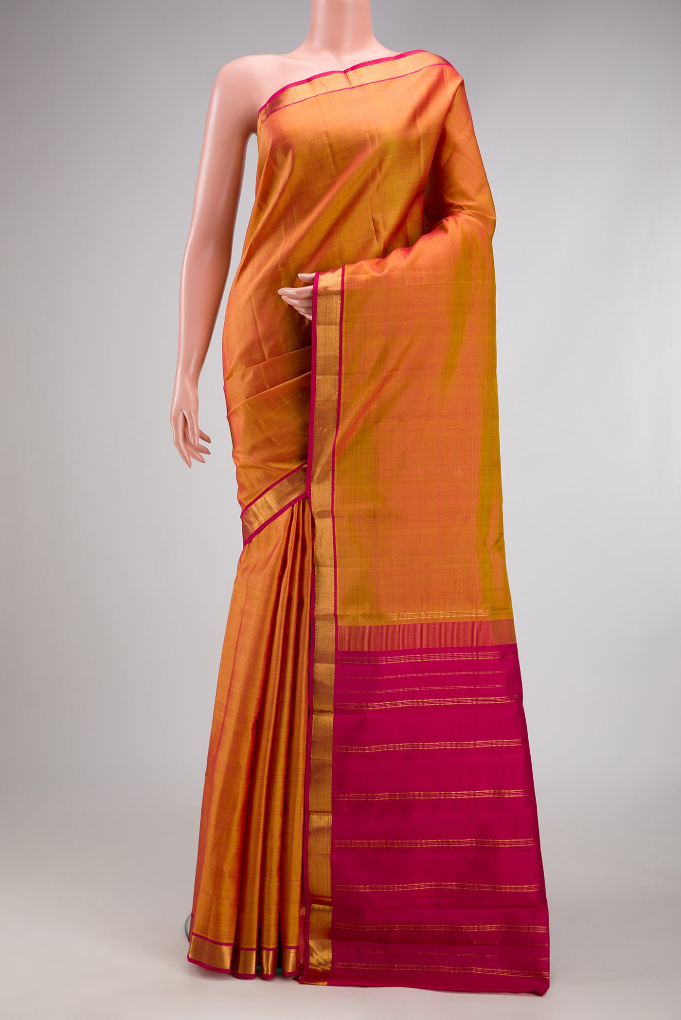 Mustard Kanjivaram Silk Saree with Plain Body and Zari Border.  displayed on a mannequin