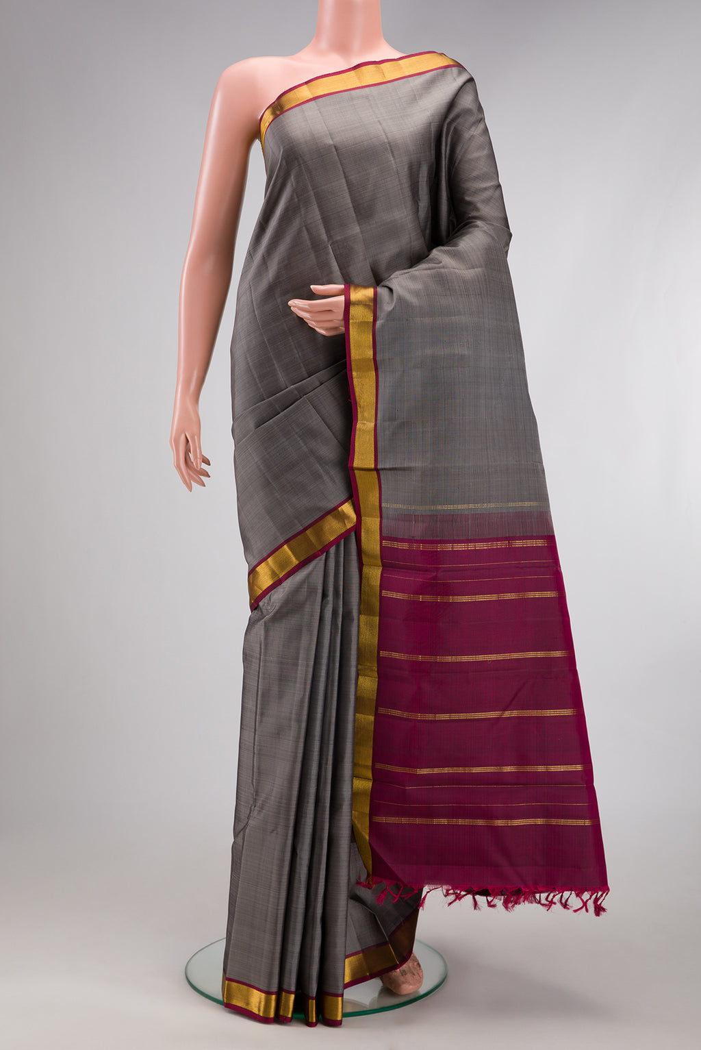 Grey Kanjivaram Silk Saree with Plain Body and Zari Border.  displayed on a mannequin
