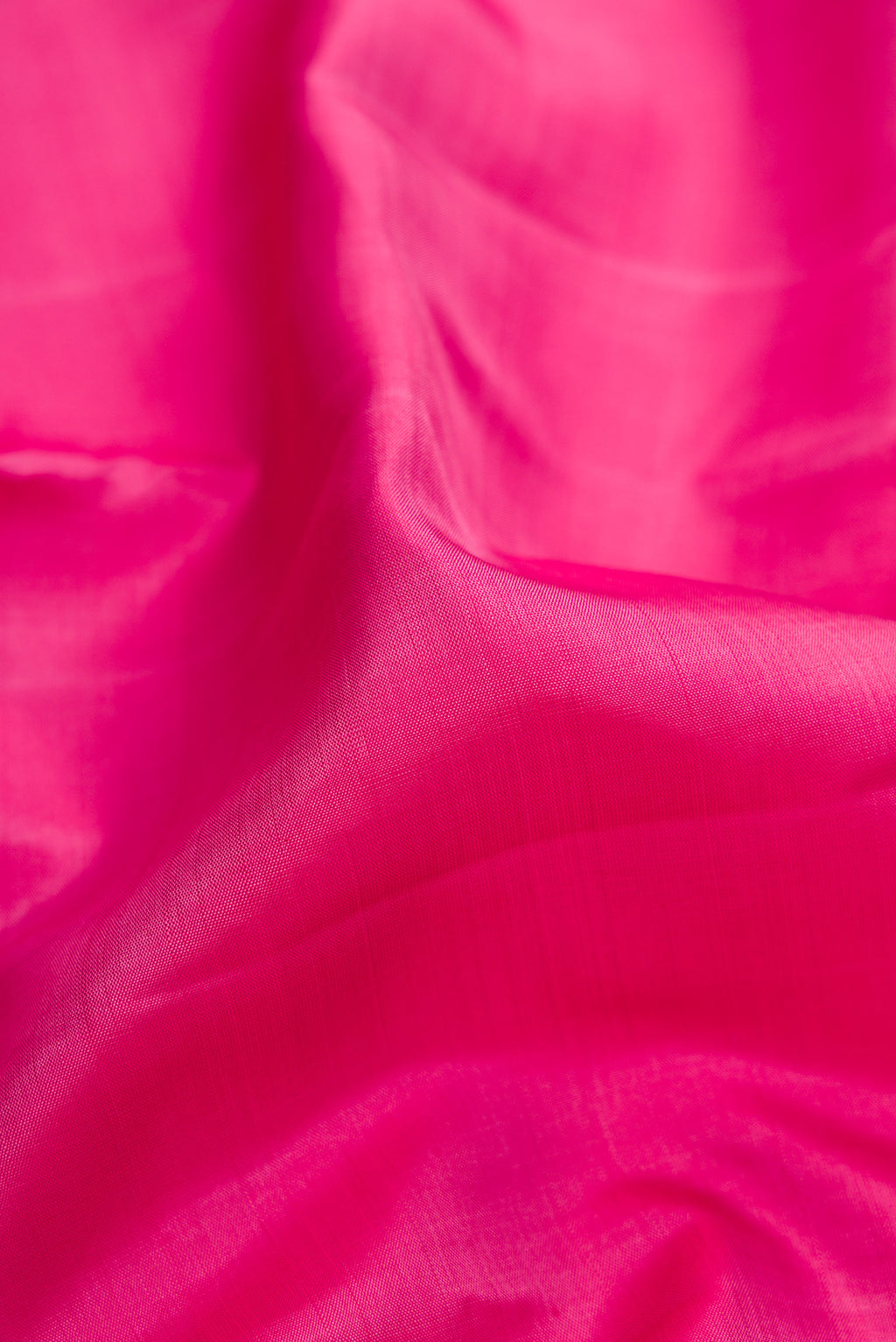 Close up of Pink Kanjivaram Silk Saree with Plain Body and Zari Border.  displaying folds