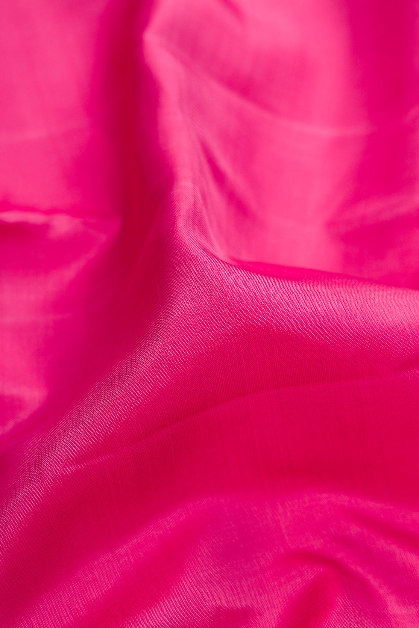 Close up of Pink Kanjivaram Silk Saree with Plain Body and Zari Border.  displaying folds